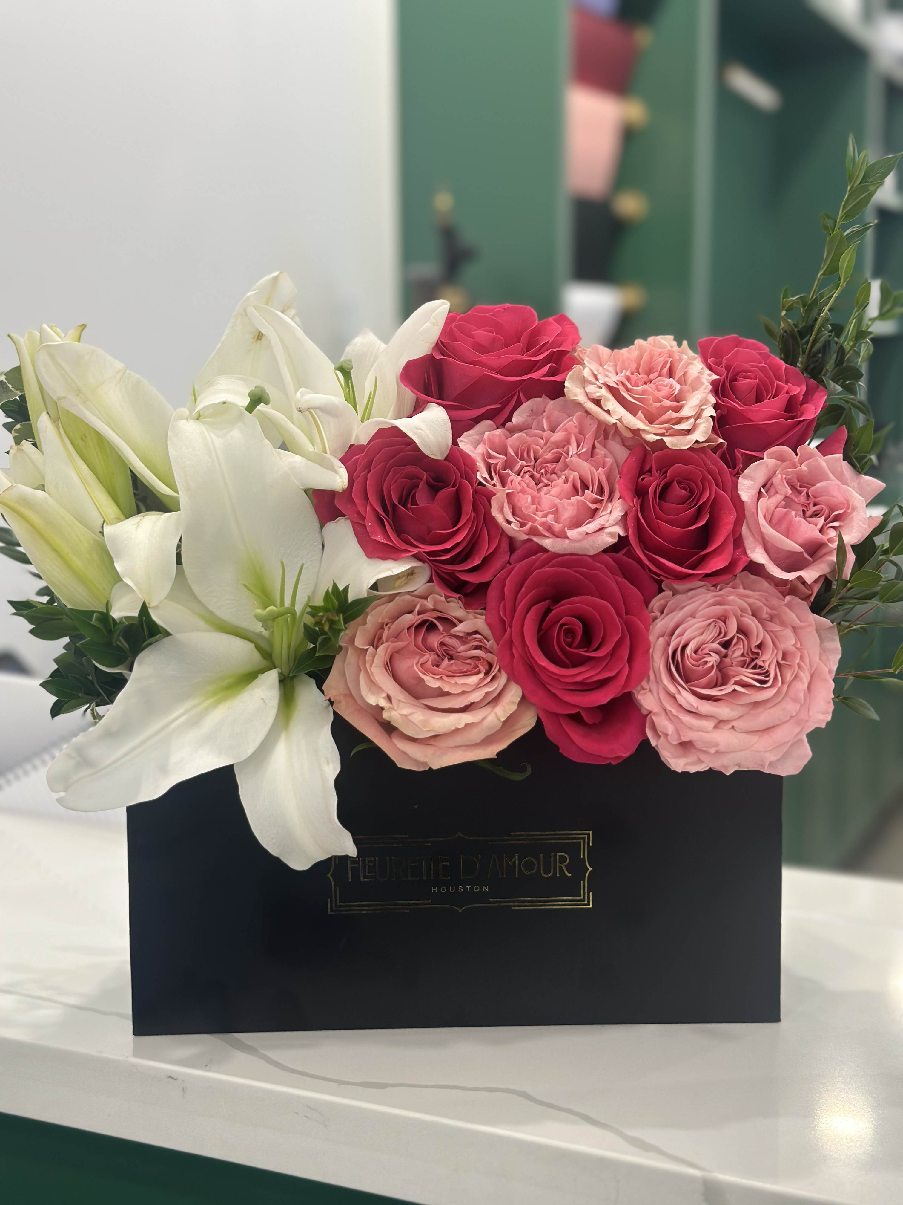 Pink and white roses with white lilies in a black box