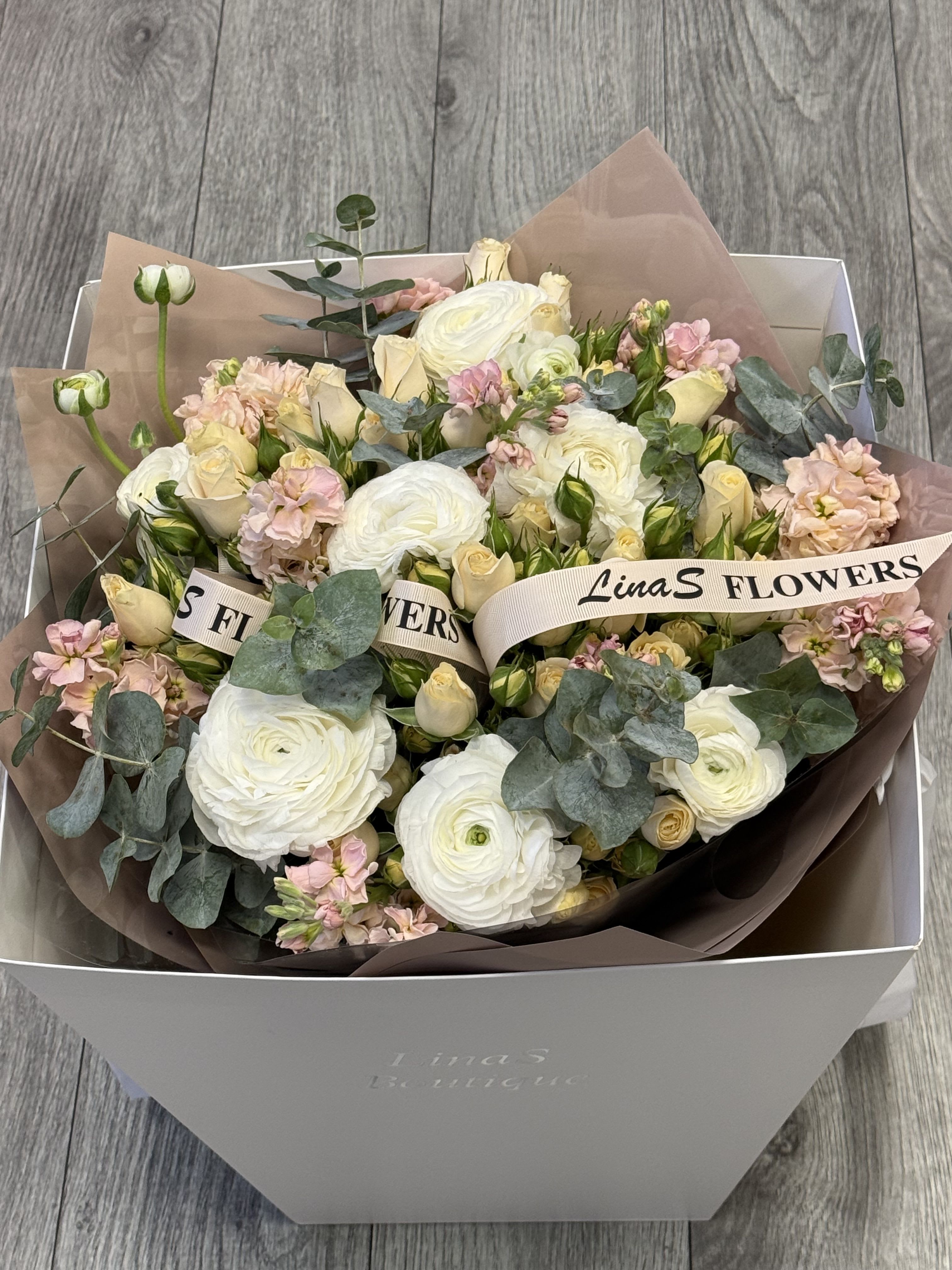 Bouquet of white and blush flowers in a gift box