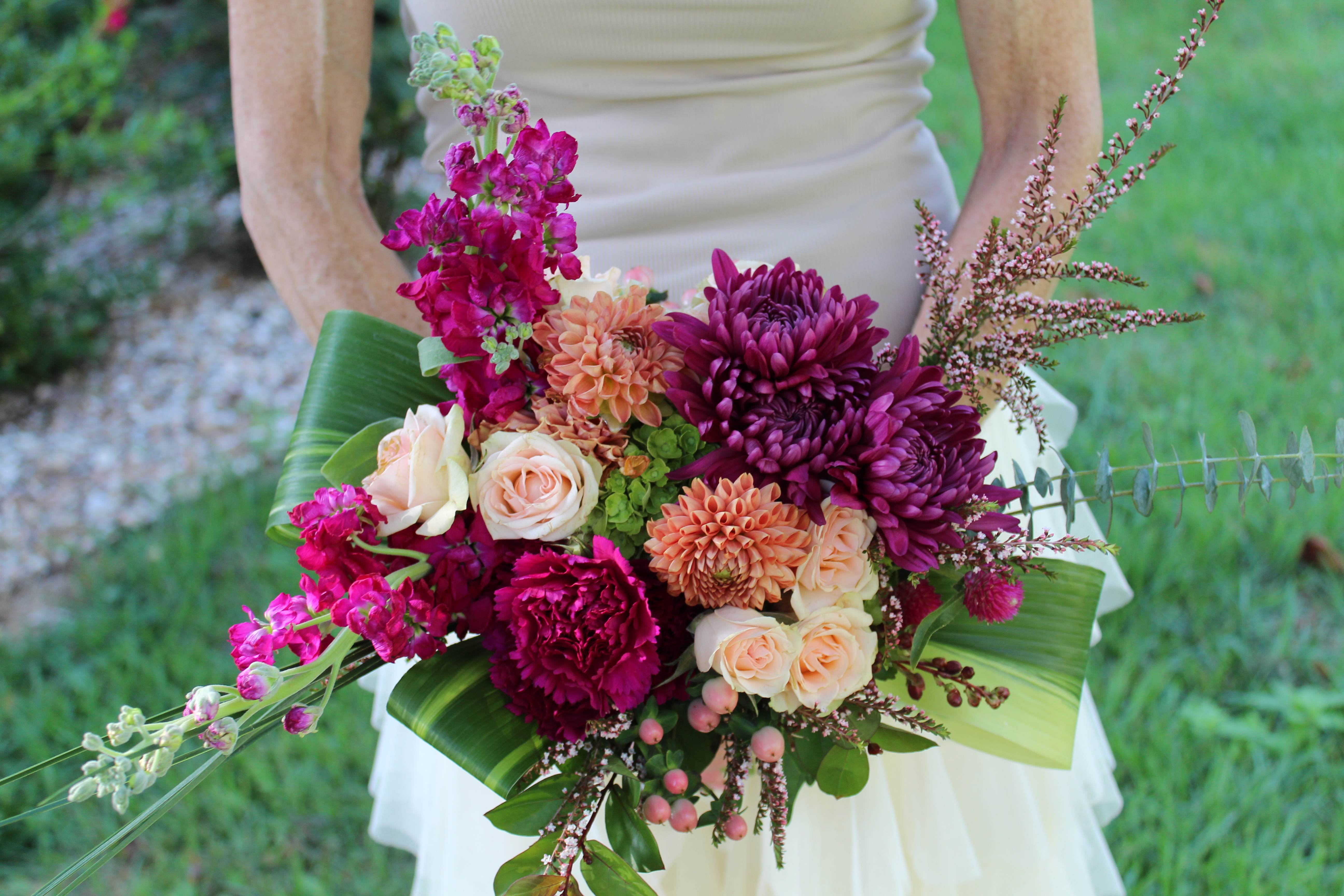Bride holding a bouquet of magenta and peach flowers