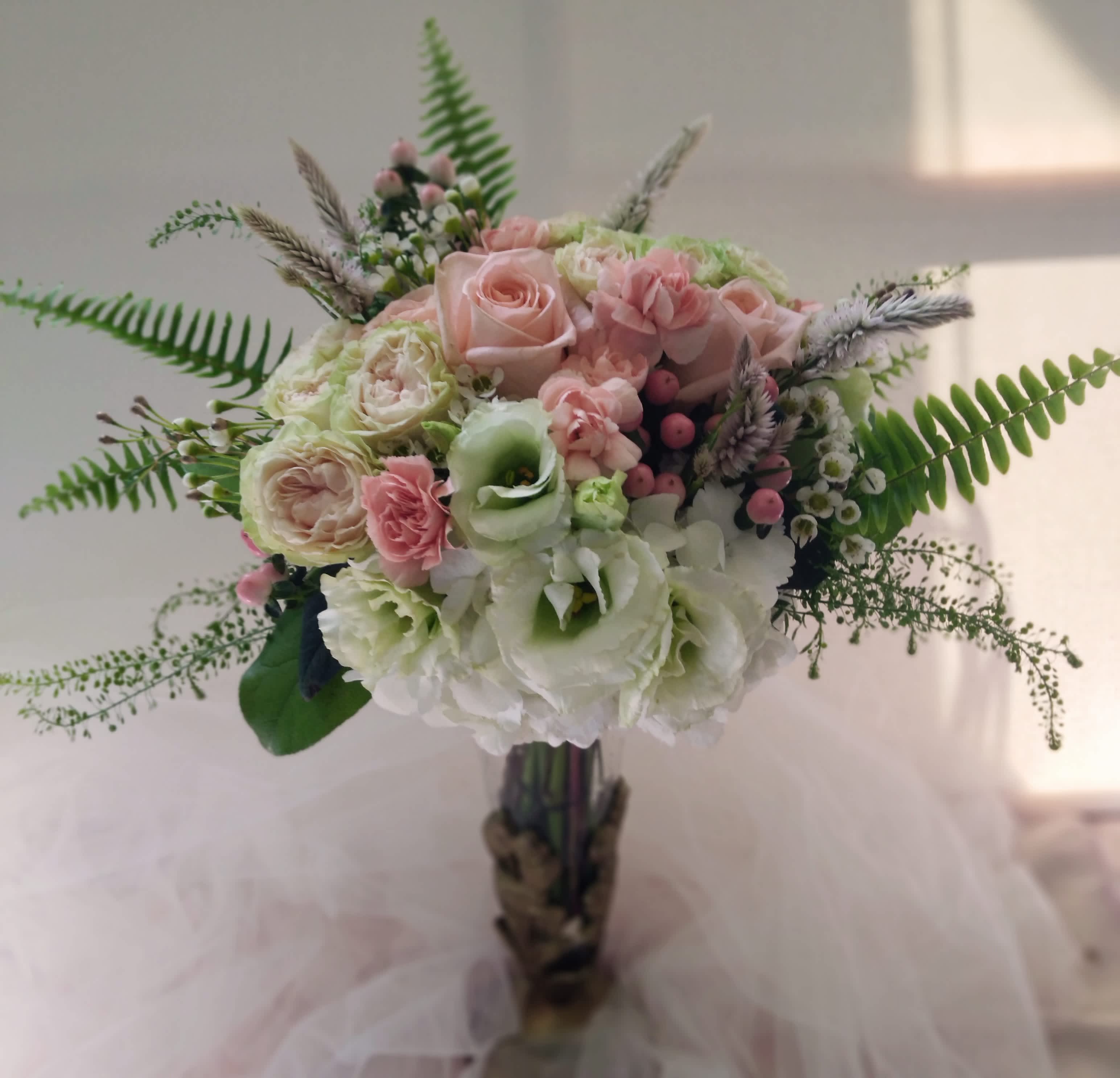 Bouquet of pink and white flowers with fern-like greenery