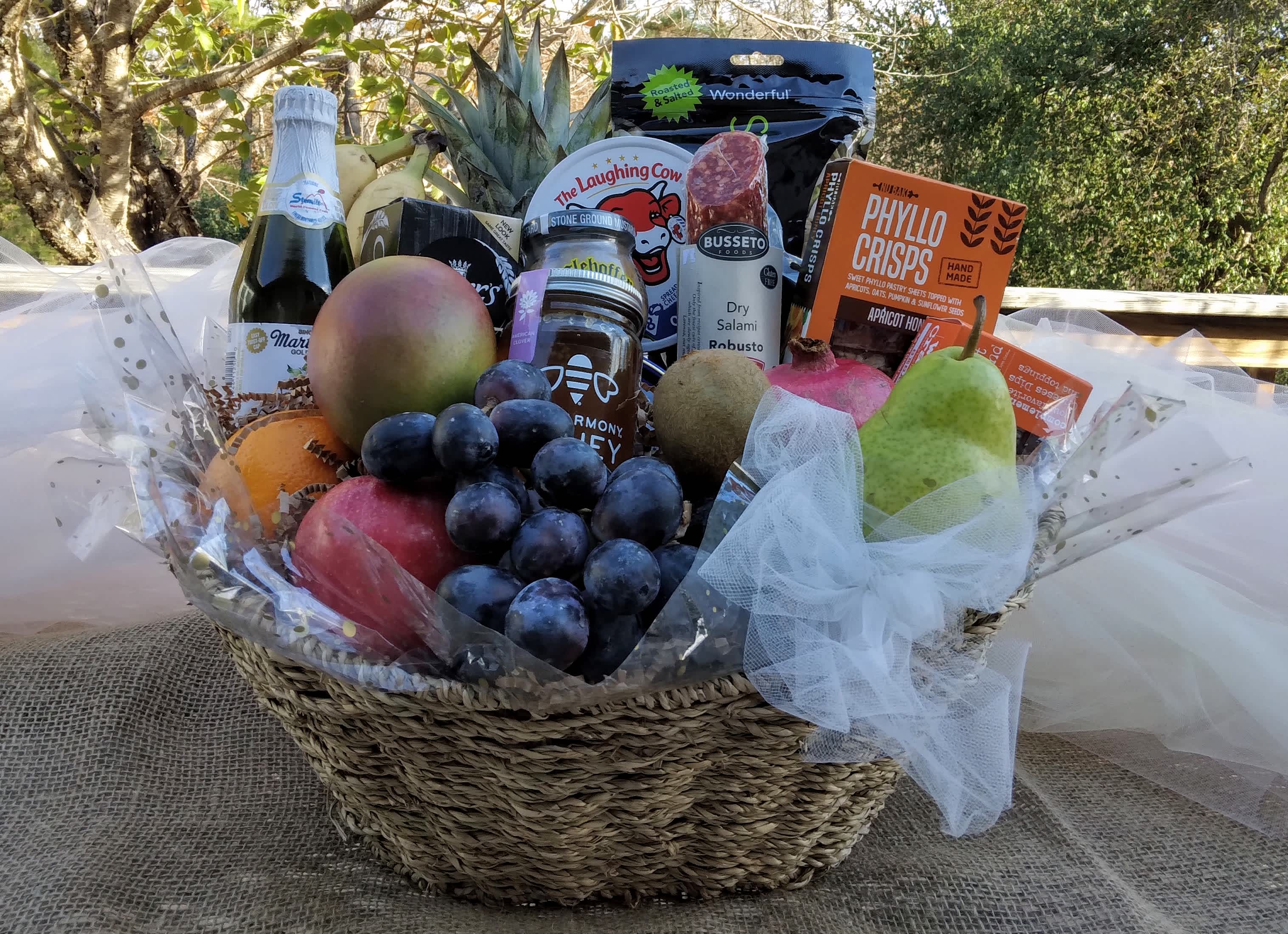 Gift basket with fruit, grapes, cheese, salami, and crackers