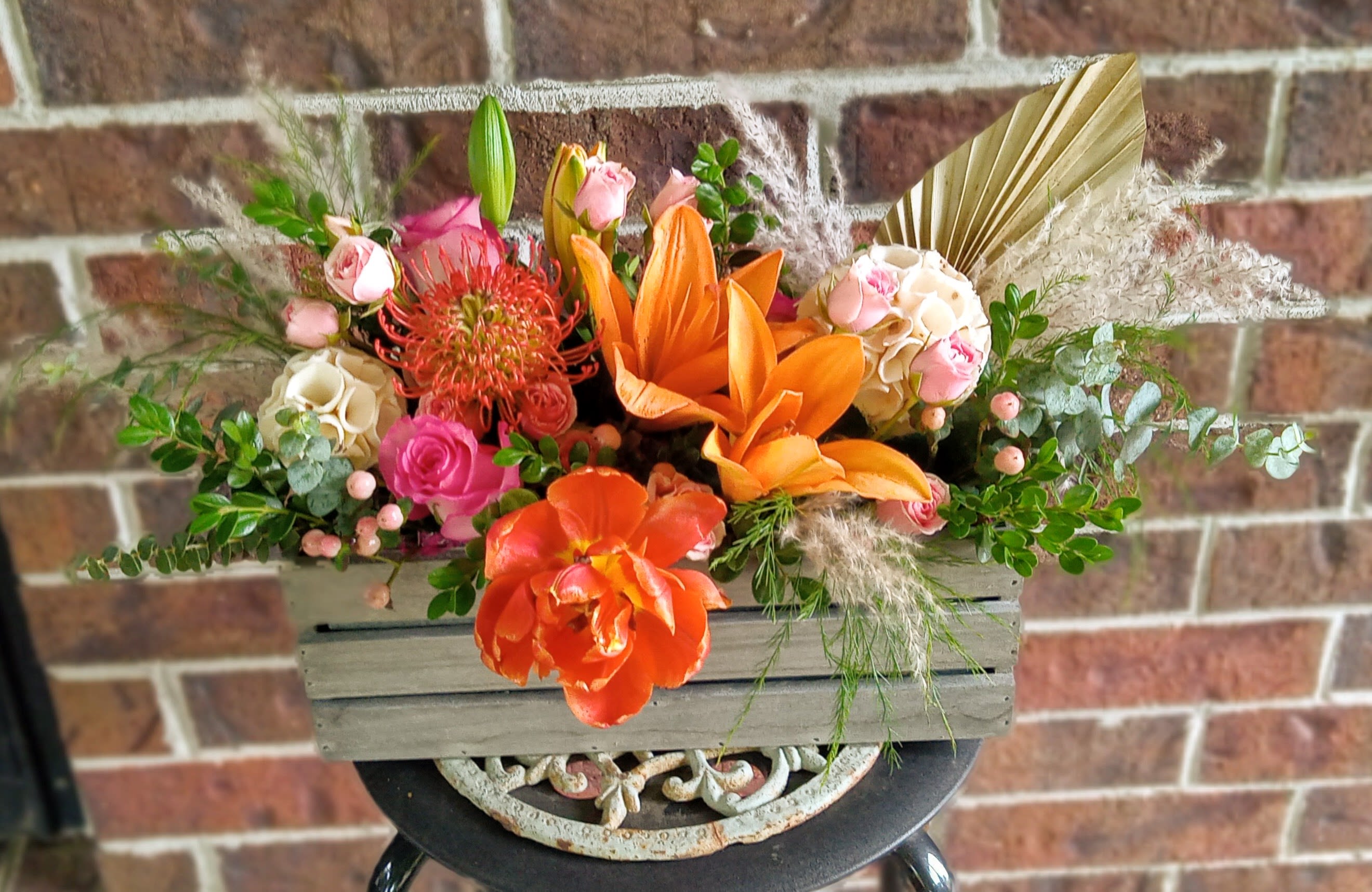 Wild and Free by BloomNation™ - A gift for your free-spirited, boho friend or significant other (crystals optional).  This trendy arrangement is a mix of orange lilies, tulips, protea and dried materials like bright pops of tulip and a sun palm. The perfect good vibes gift for any occasion!  Approximate Dimensions: 22"D x 15"H 