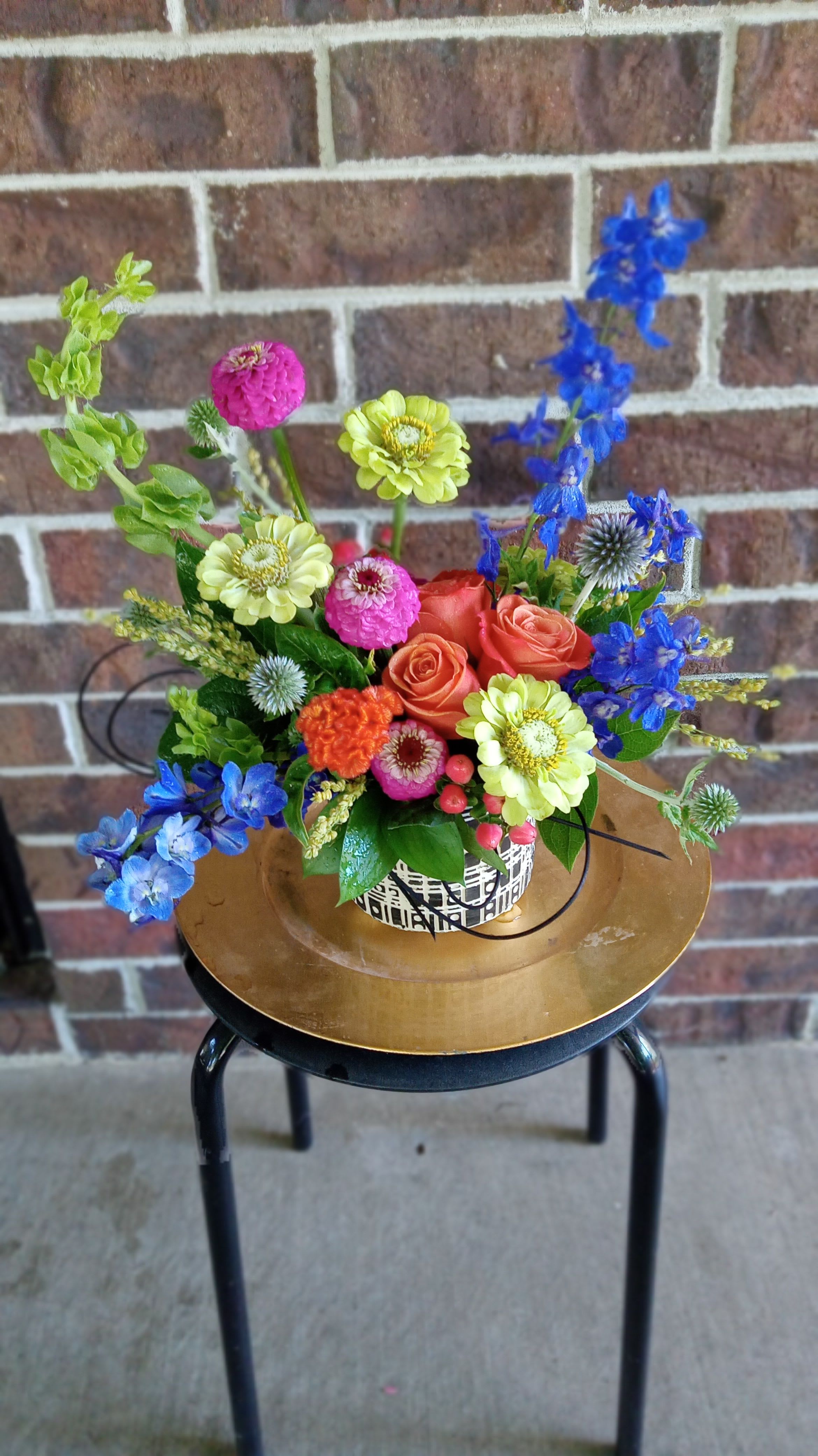 Colorful mixed flower arrangement in a patterned container