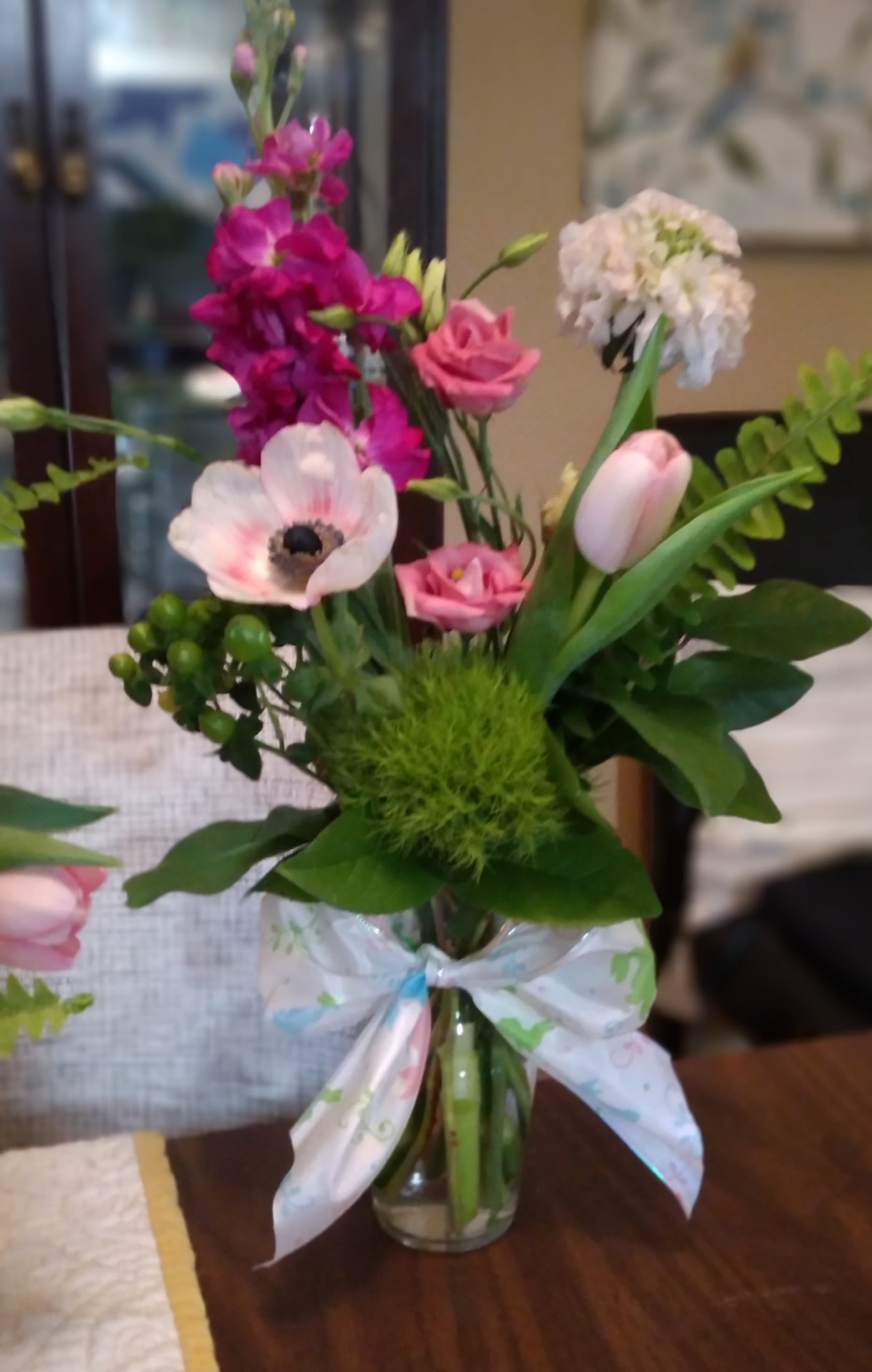 Pink and white mixed bouquet in a glass vase with a ribbon