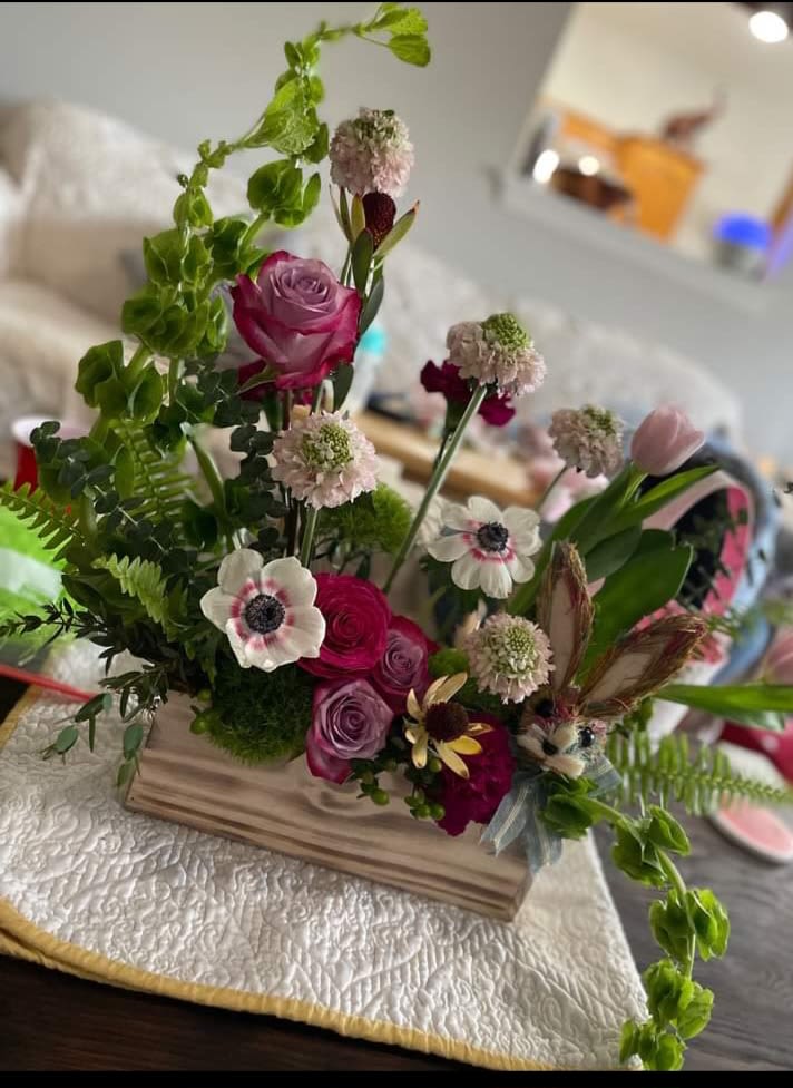 Mixed bouquet with pink roses and white anemones in a wooden base