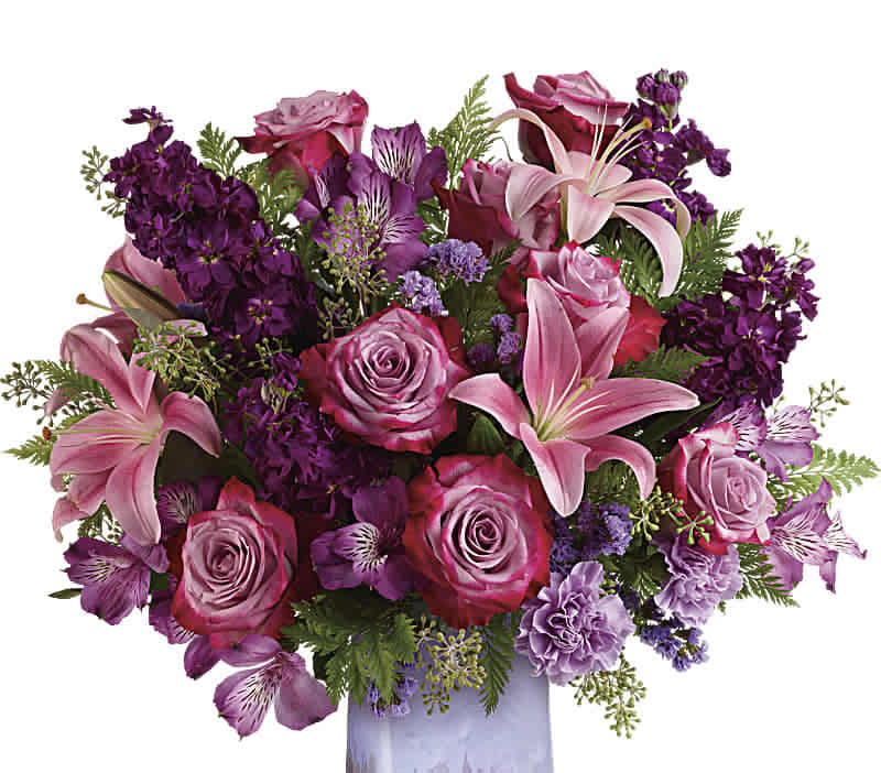 Amethyst Jewel - Like a rare jewel, this regal arrangement of lavender roses and pink lilies is naturally breathtaking. It’s presented in a hand-blown art glass vase that shimmers with a beautiful iridescent finish. This bouquet features lavender roses, pink asiatic lilies, purple alstroemeria, lavender carnations, lavender sinuata statice, seeded eucalyptus, and leatherleaf fern.