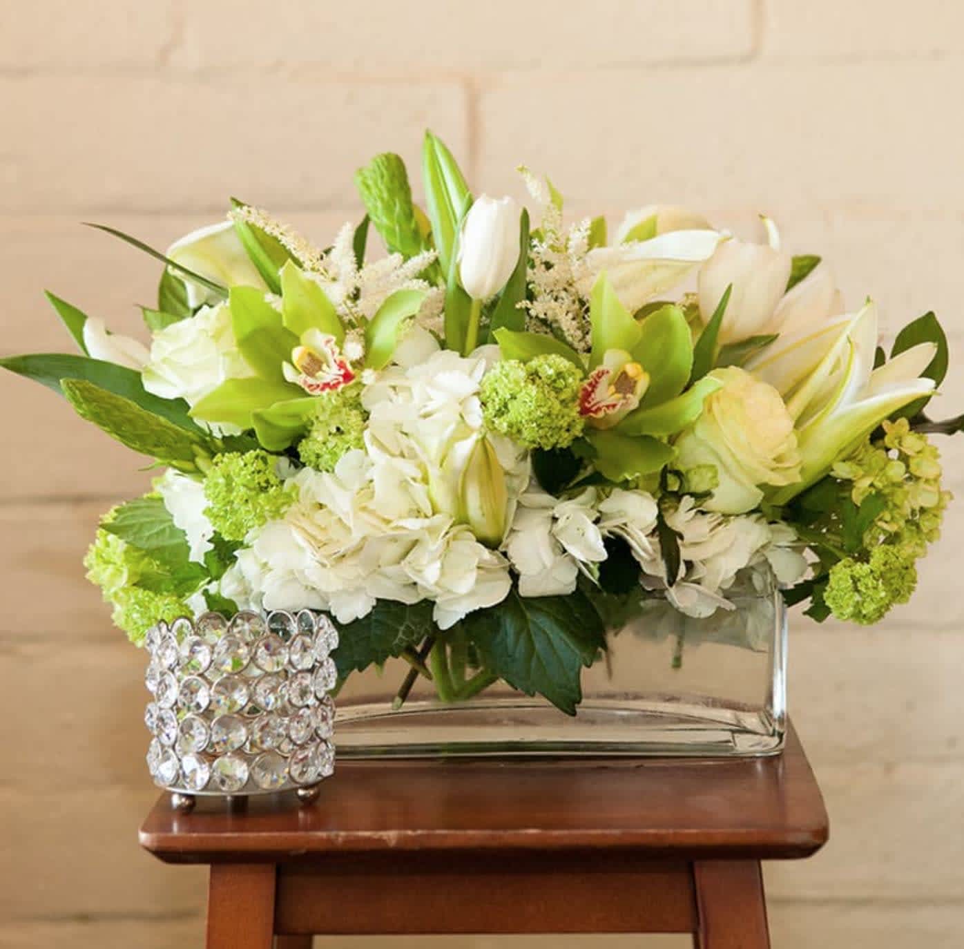 Timeless Beauty - This green and white bouquet is an all time favorite. The modern look, freshness, and elegance set this apart as a favorite. This bouquet is designed in a rectangle clear glass vase and is filled with an array of beautiful green and white blooms. This truly is a timeless beauty.