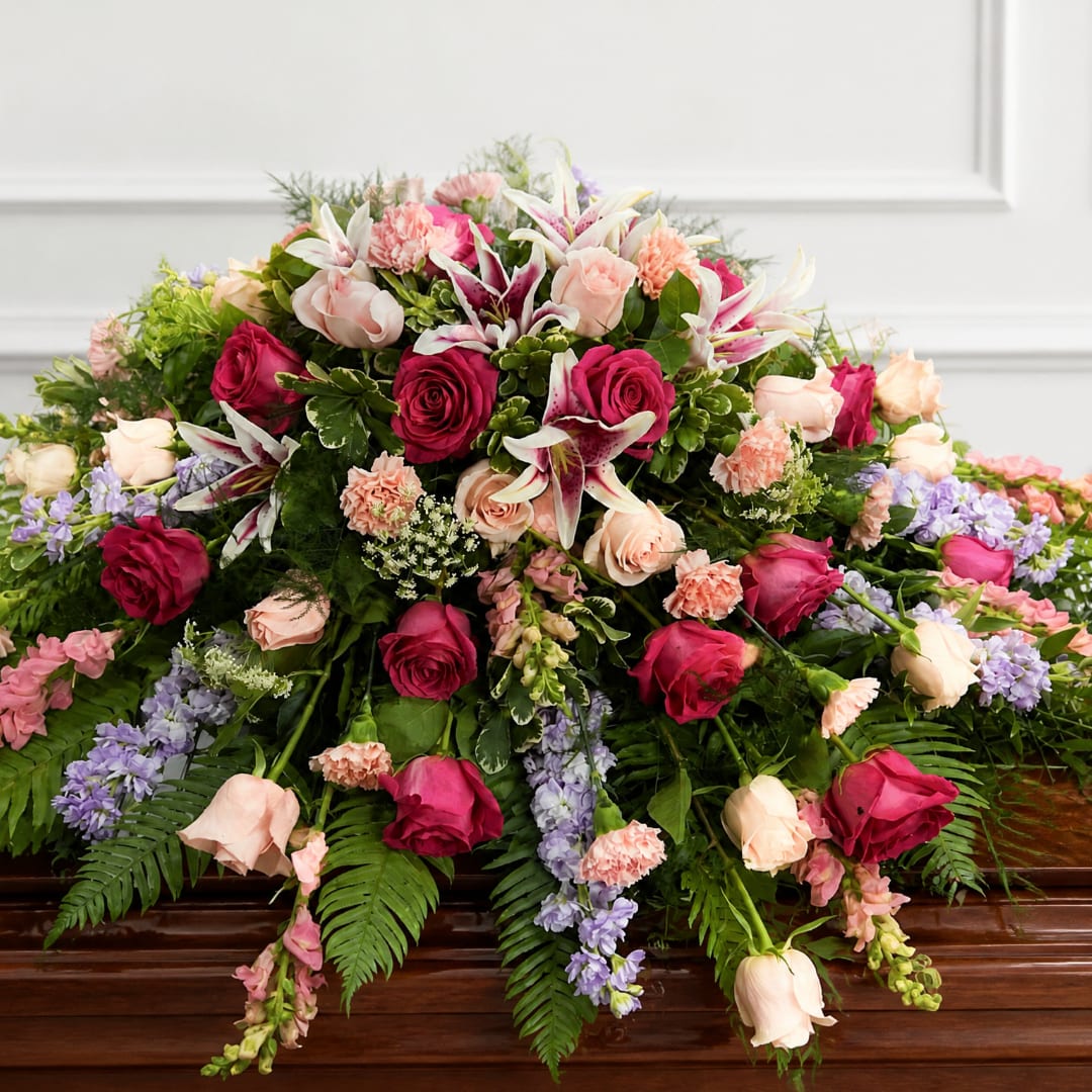 Large floral spray with roses, lilies, carnations, and lavender flowers