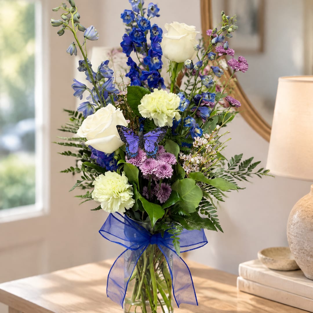 Mixed bouquet in a glass vase with blue, white, and purple flowers