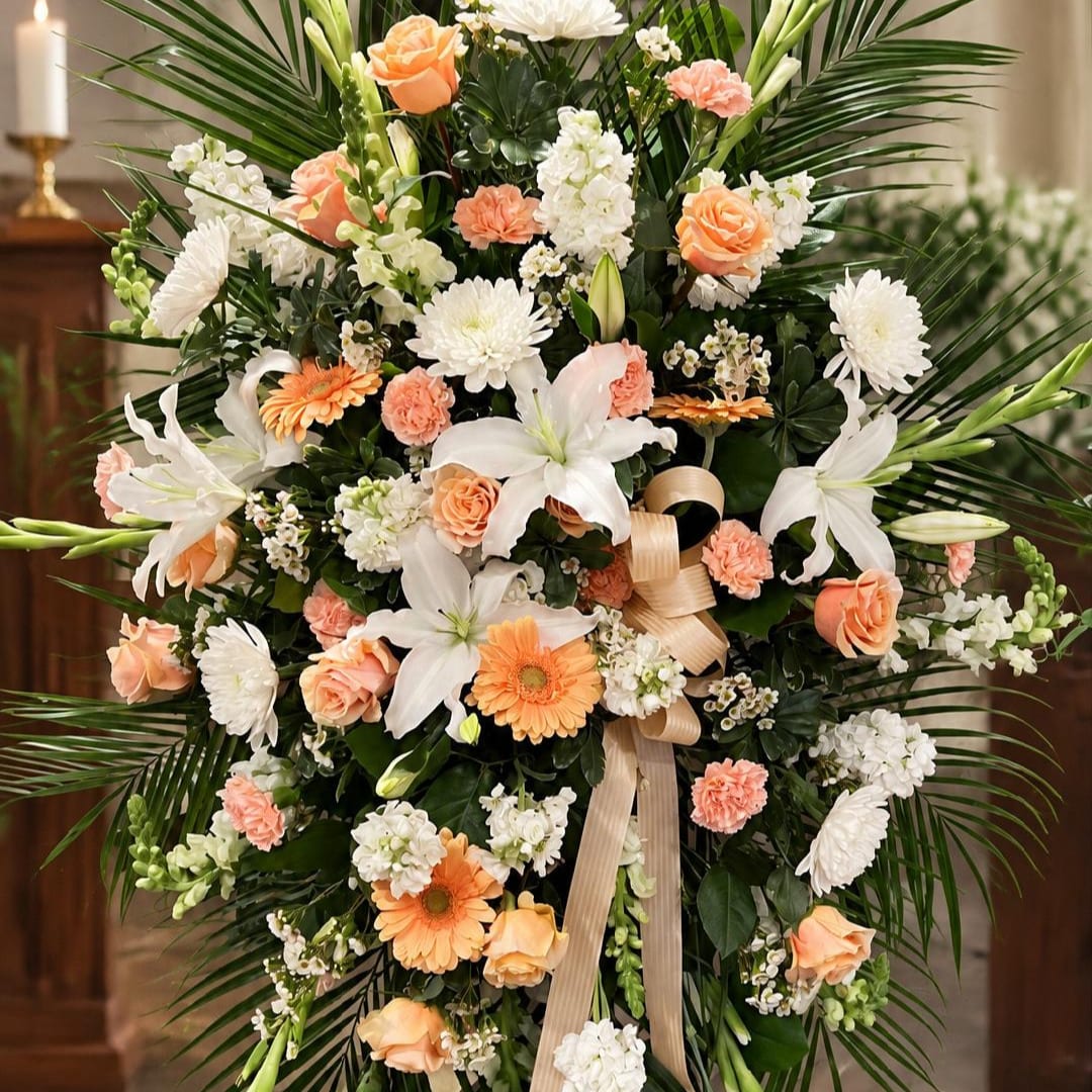 Large floral standing spray with white lilies, peach roses, and white chrysanthemums