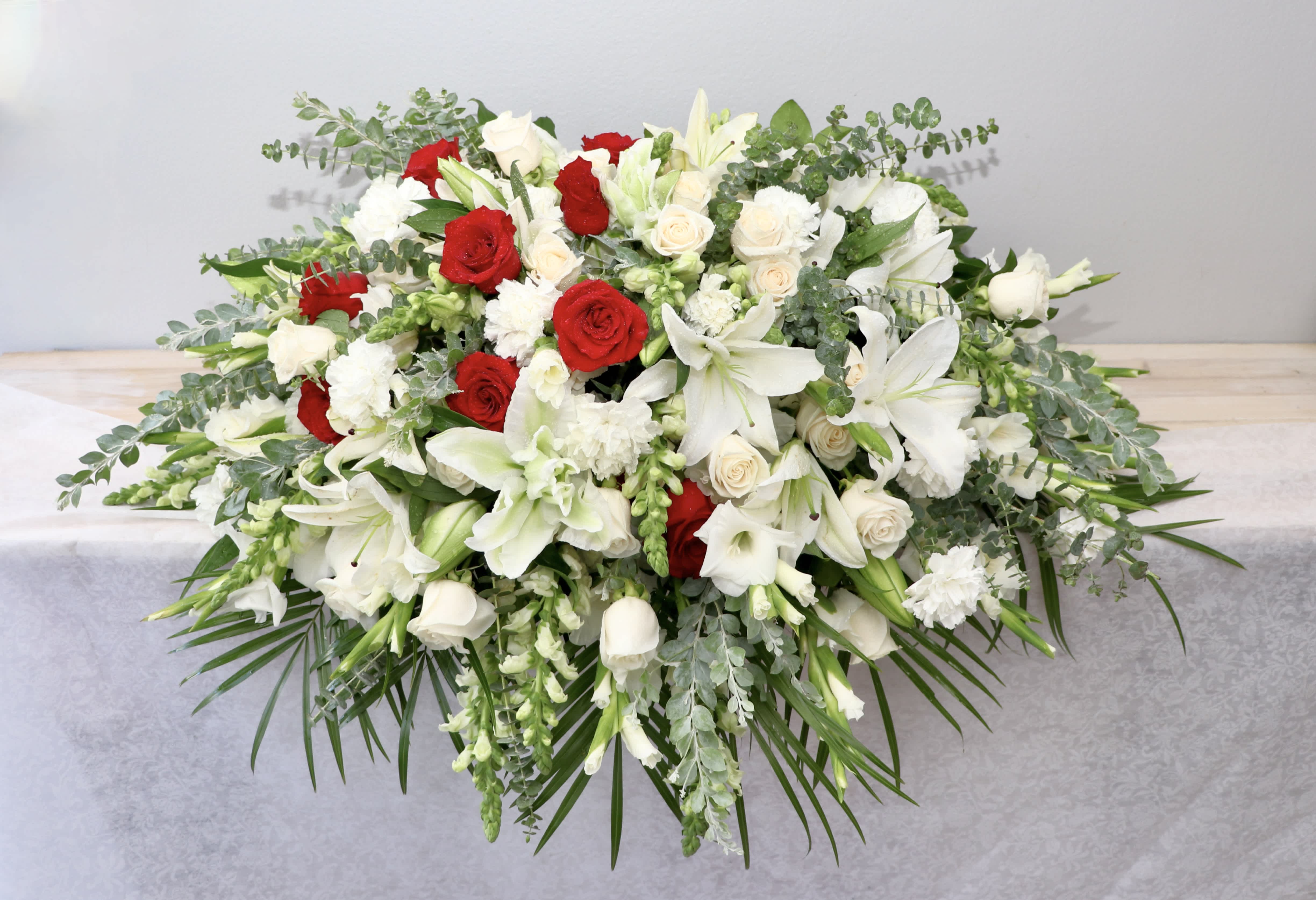 White and red floral casket spray with lilies and roses