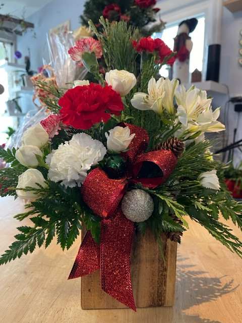 Christmas floral arrangement with red and white flowers in a wooden box