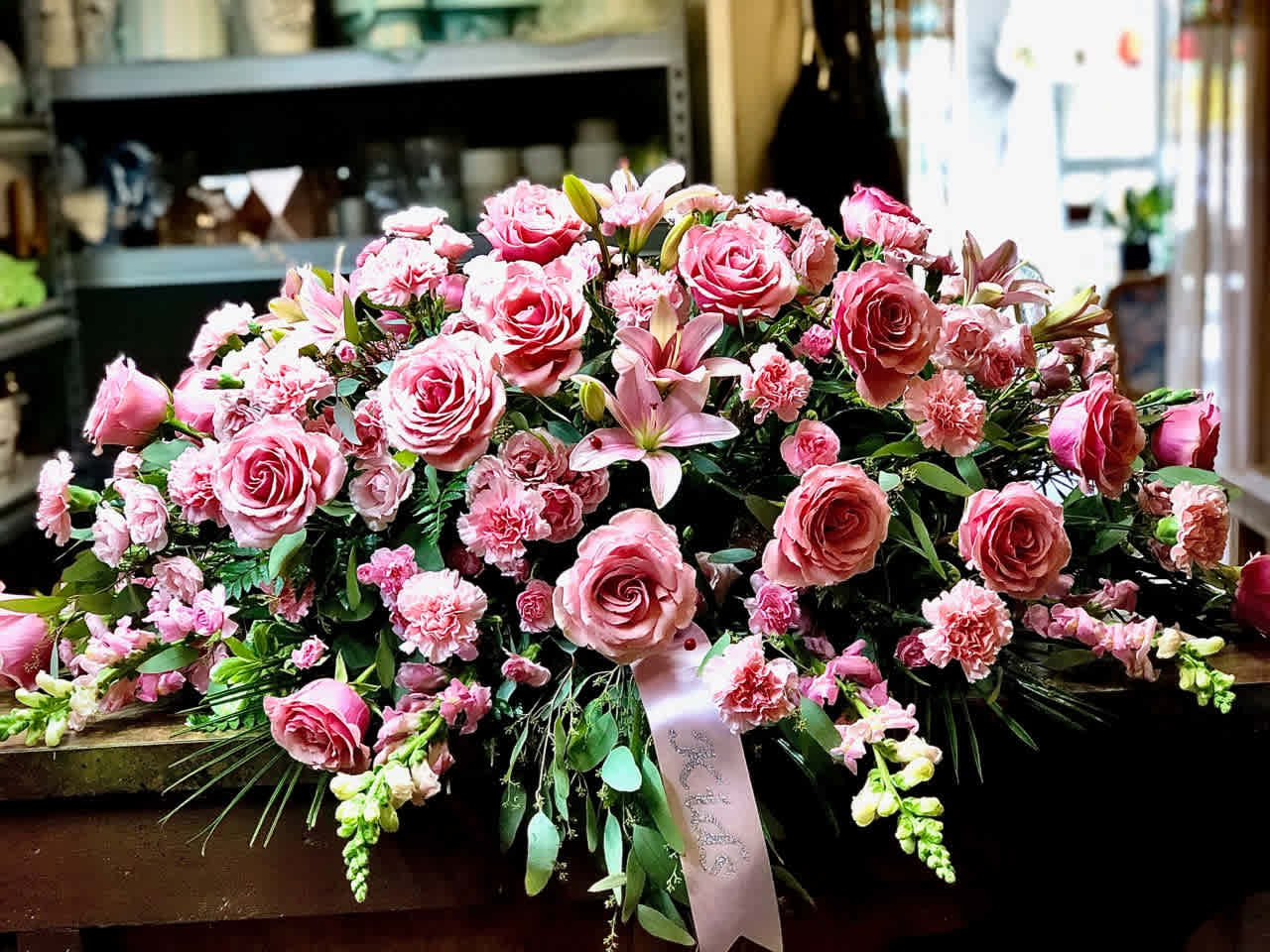 Large pink floral spray with roses, lilies, and carnations