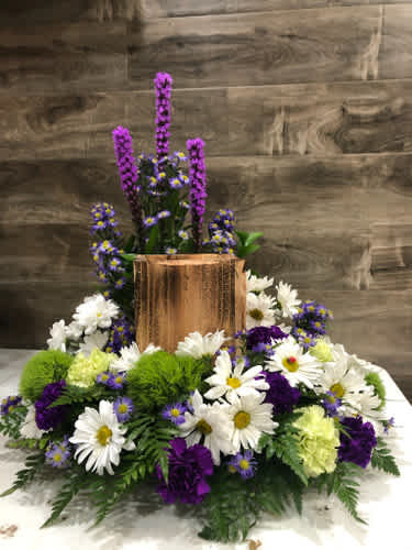 White daisies and purple flowers arranged around a copper vase