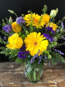Yellow and purple mixed bouquet in a glass vase