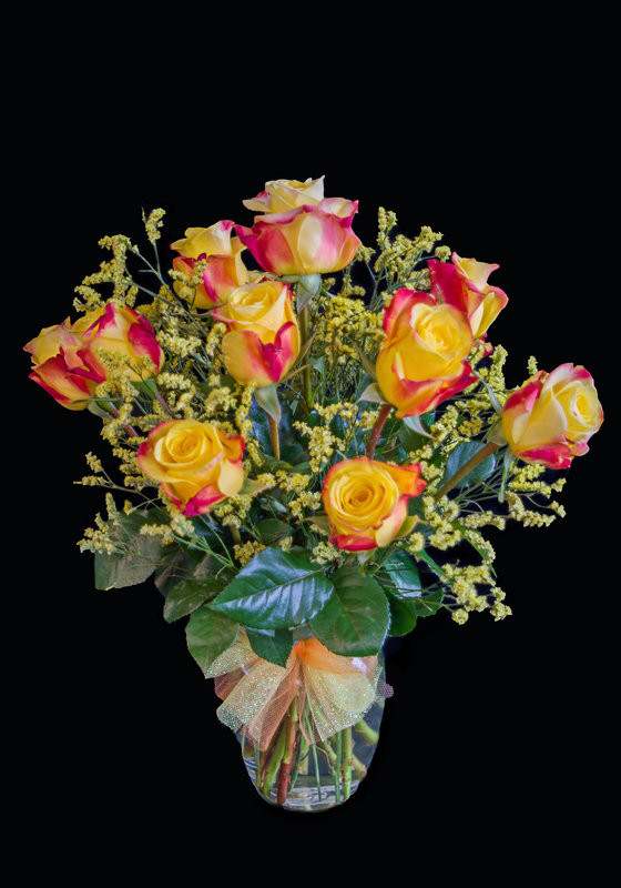 Bouquet of yellow and pink roses in a clear glass vase