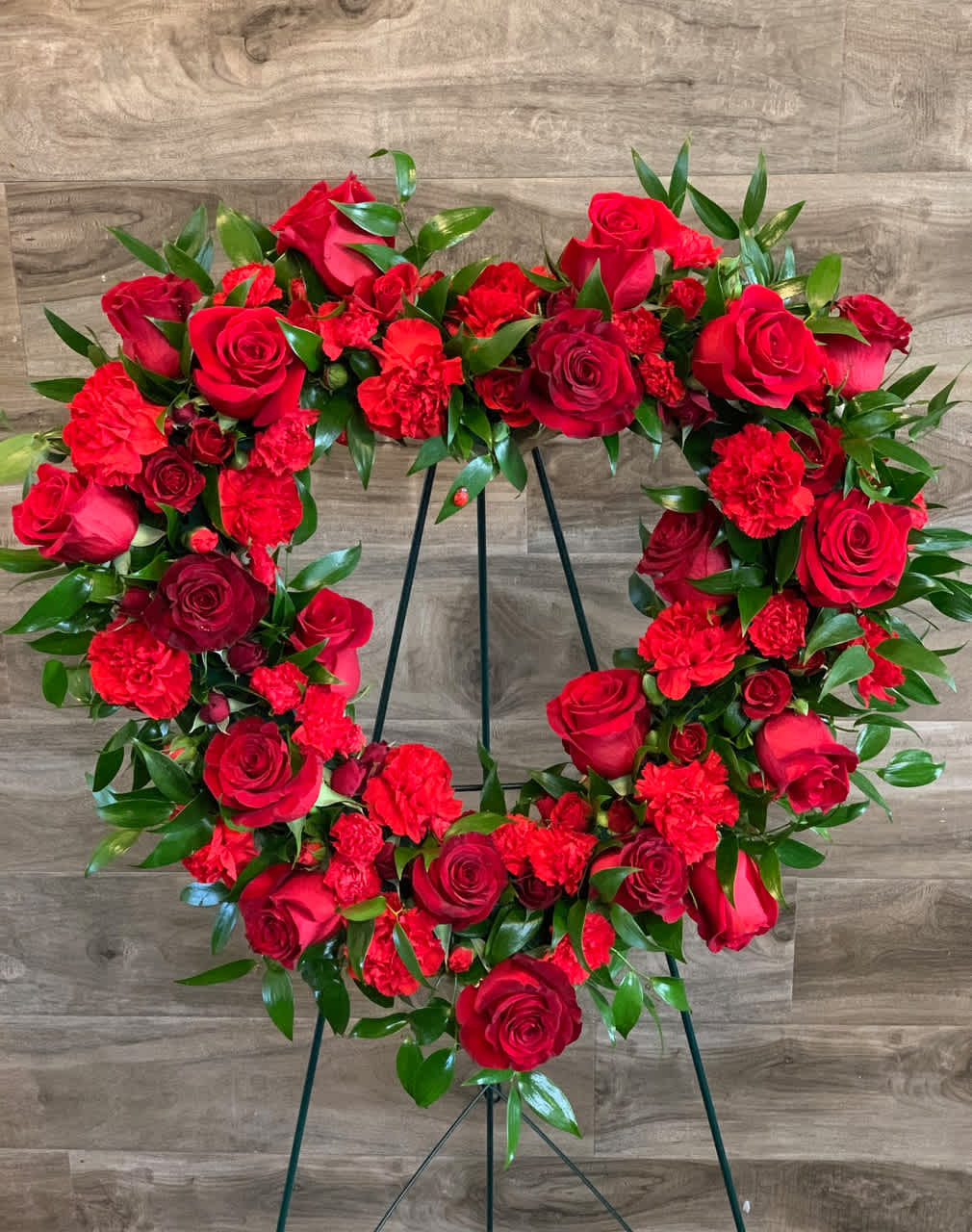 Red rose and carnation wreath on a stand