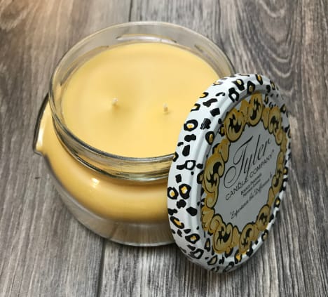 Yellow candle in a glass jar with a patterned lid