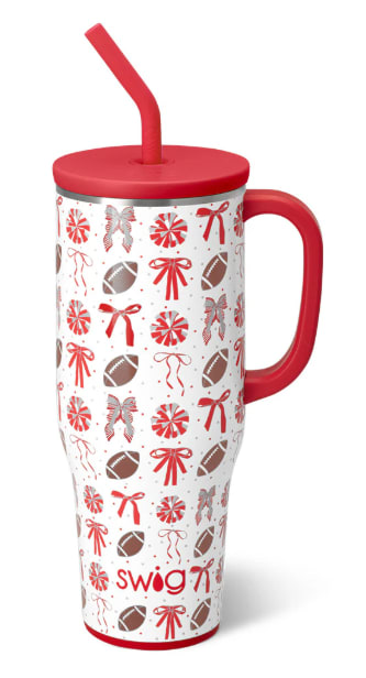 Red-lidded travel tumbler with straw and football-and-bow pattern