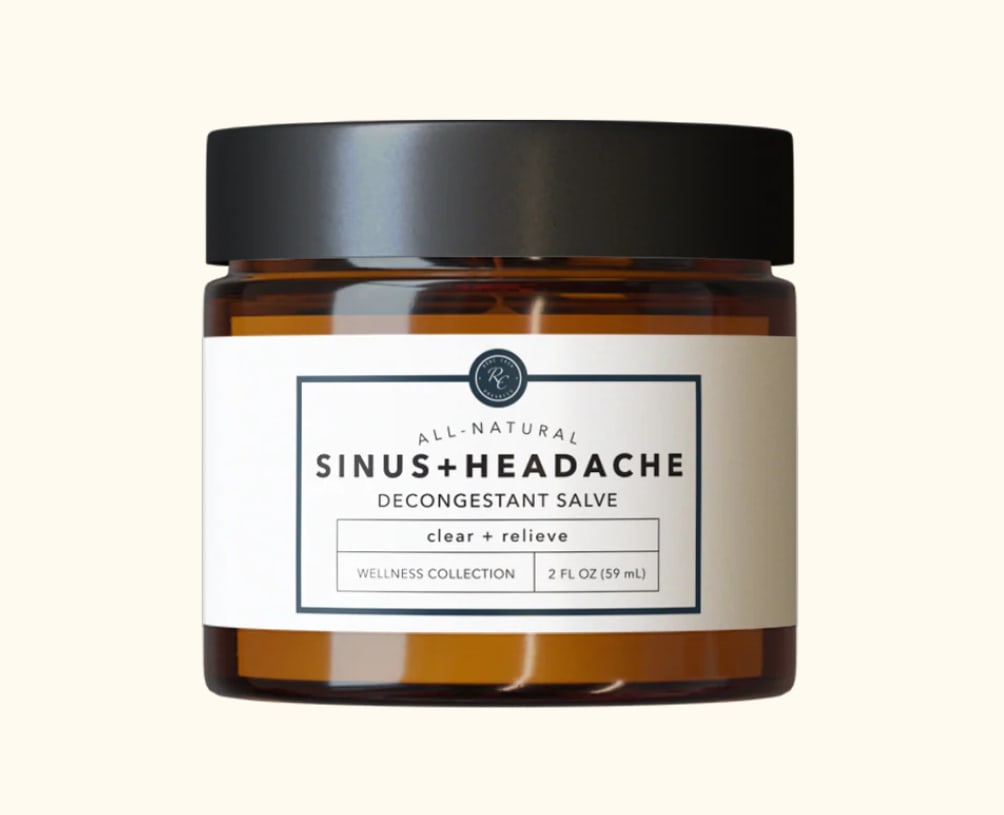 Amber glass jar of sinus and headache decongestant salve with white label and black lid