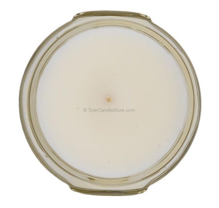 Round white candle in a clear glass jar