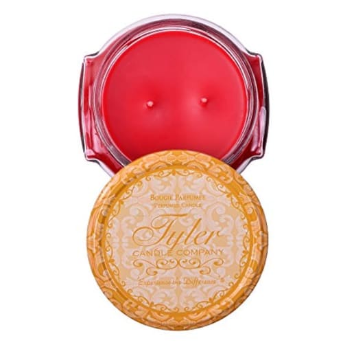 Two round candles in decorative tins, one red and one gold