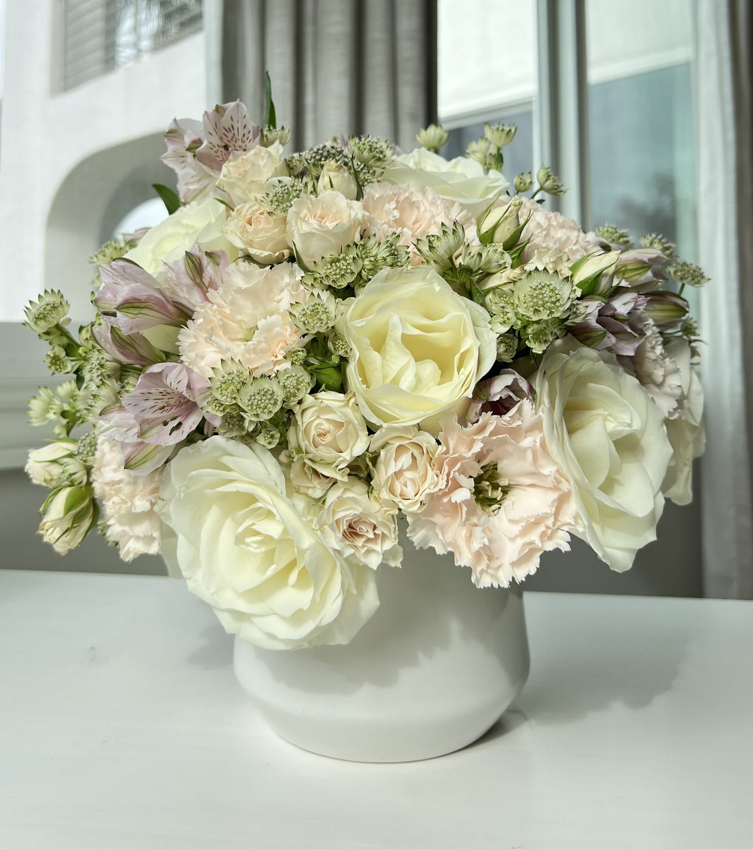 Cream and blush bouquet in a white vase