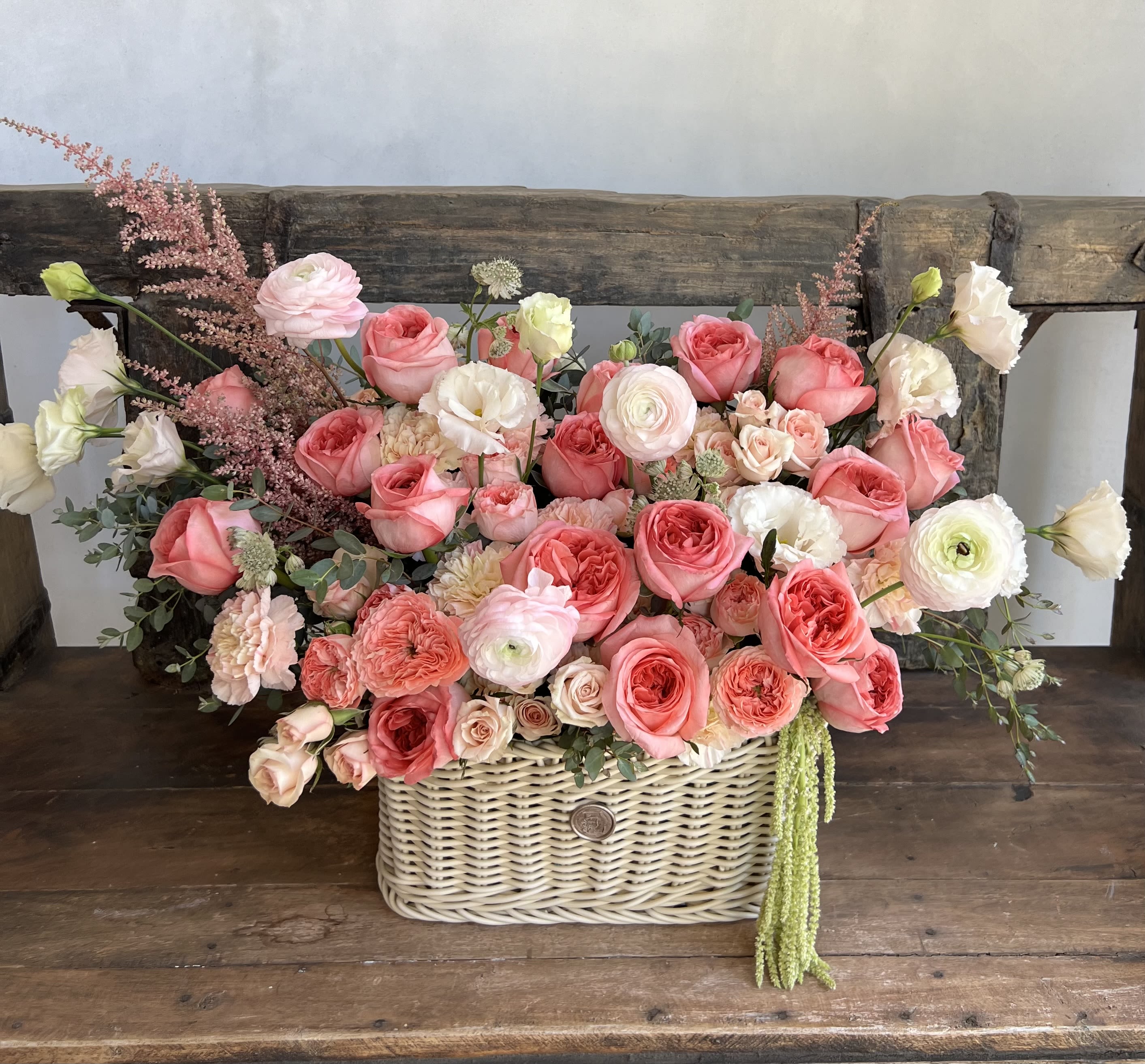 Basket arrangement of pink and white roses with mixed blooms