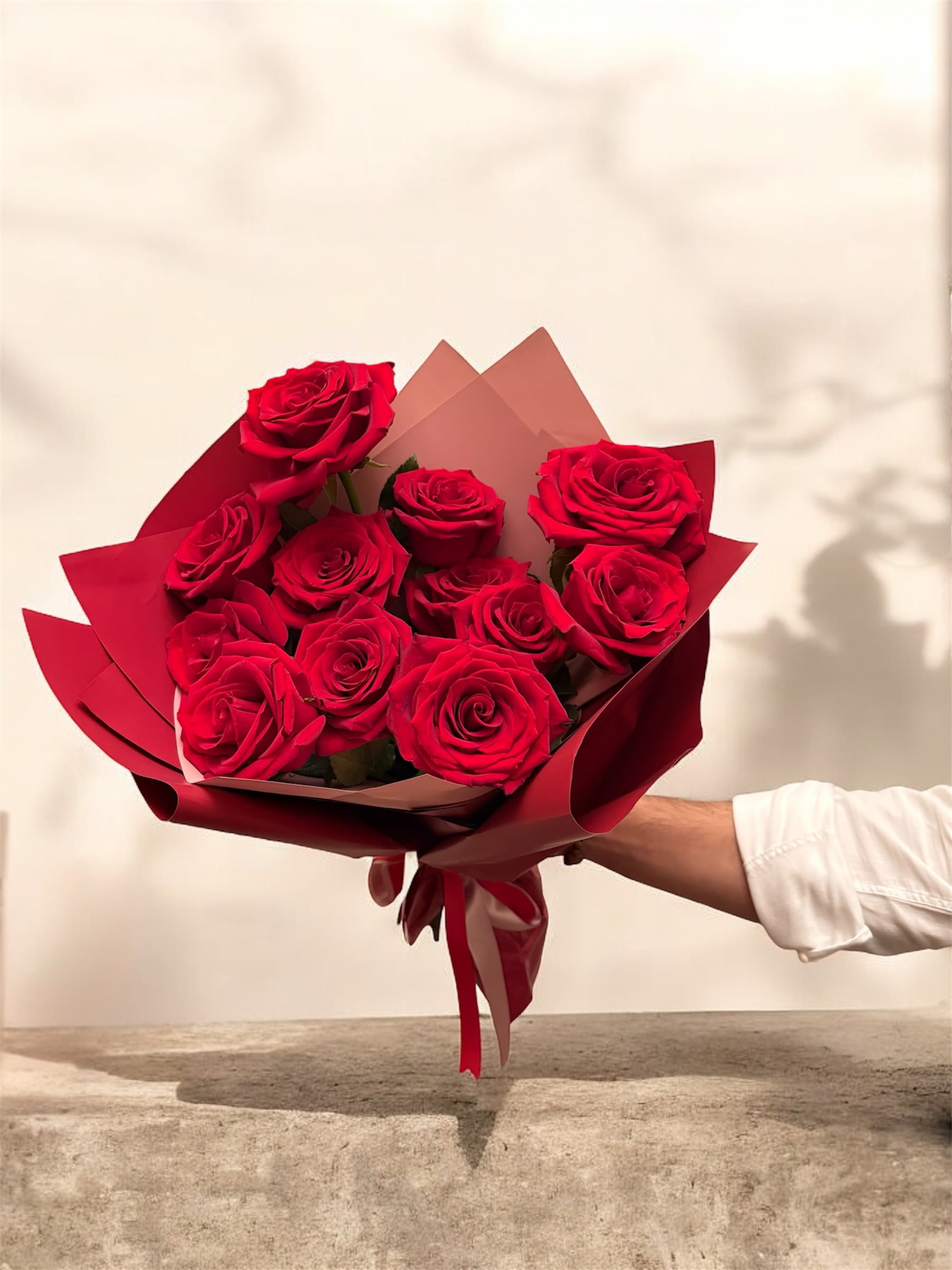 Bouquet of red roses wrapped in burgundy paper