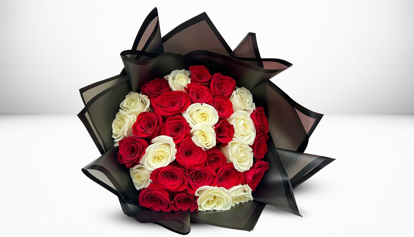 Bouquet of red and white roses wrapped in black paper