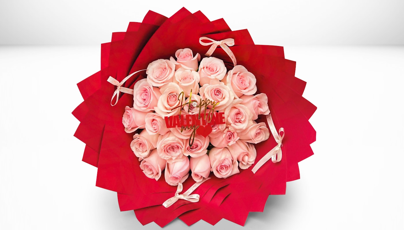 Pink roses arranged in red wrapping with small ribbon bows