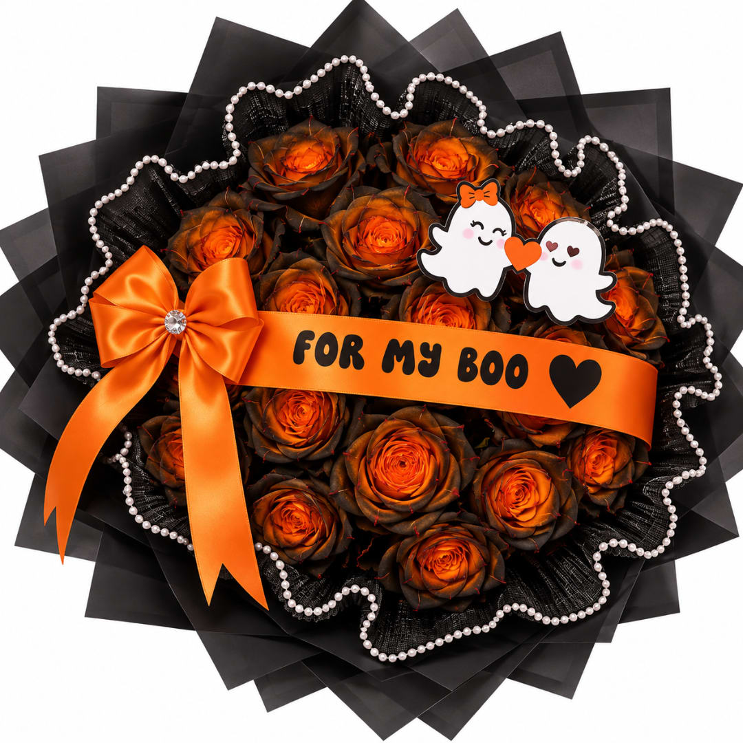 Orange roses in a black wrapped bouquet with an orange ribbon and ghost topper