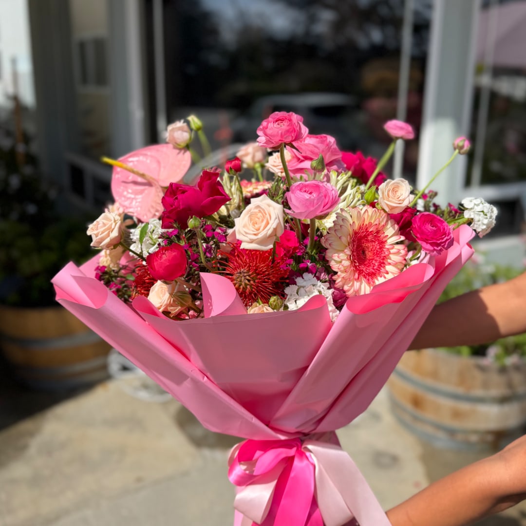 Pink bouquet with roses and gerbera daisies wrapped in pink paper