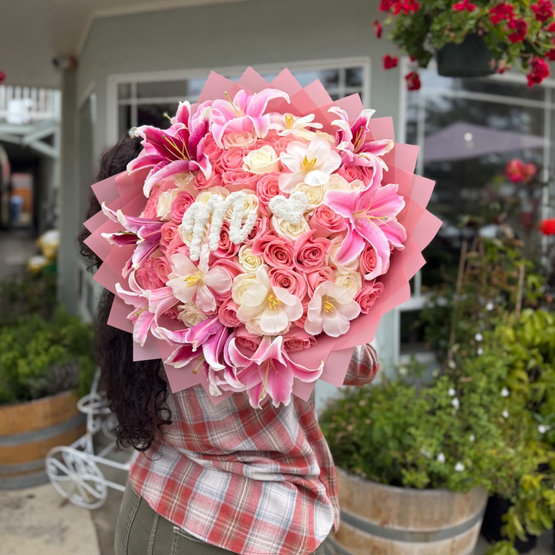 Large pink bouquet with roses and lilies wrapped in pink paper