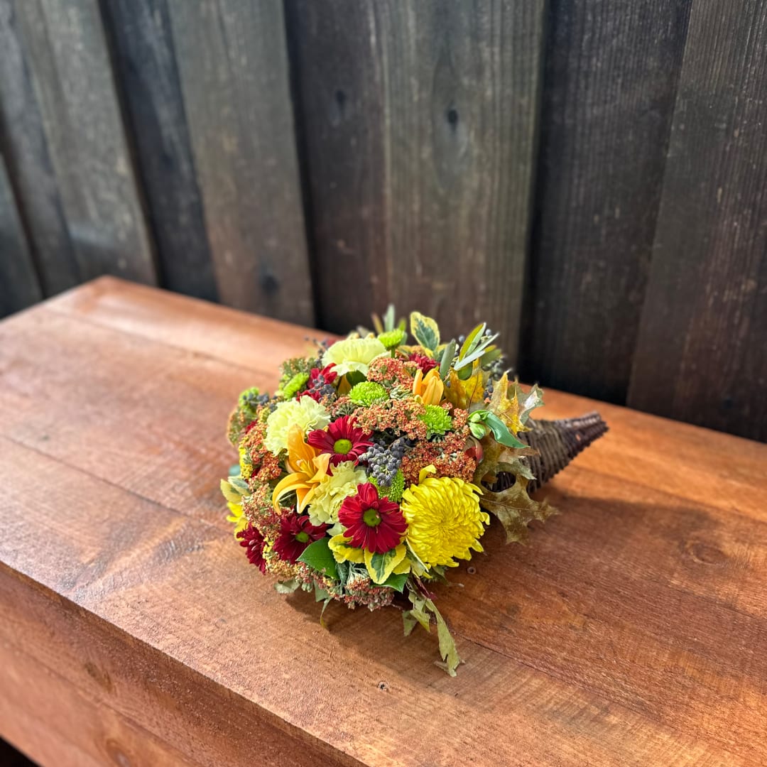 Small bouquet of yellow and red flowers on a wooden table
