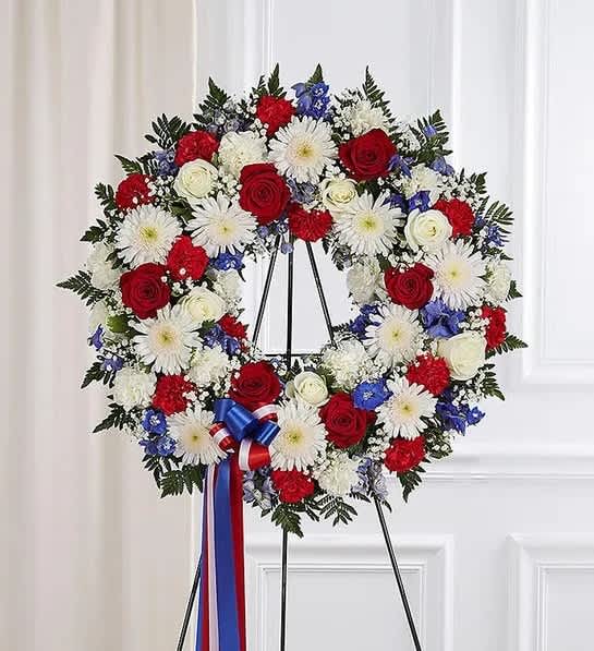 Serene Blessings™ Red, White &amp; Blue Standing Wreath - They served their country with honor and pride, so it’s only fitting to honor them with a beautiful symbol of eternal life. Our patriotic standing wreath arrangement is meticulously crafted by our expert florists to honor a brave veteran who has passed away. Filled with lush blooms in red, white and blue, it’s a fitting final tribute for the funeral services.  •Appropriate for the funeral home  •Easel may not be available in all areas  •Our florists hand-design each arrangement, so colors and assortment may vary based on local availability