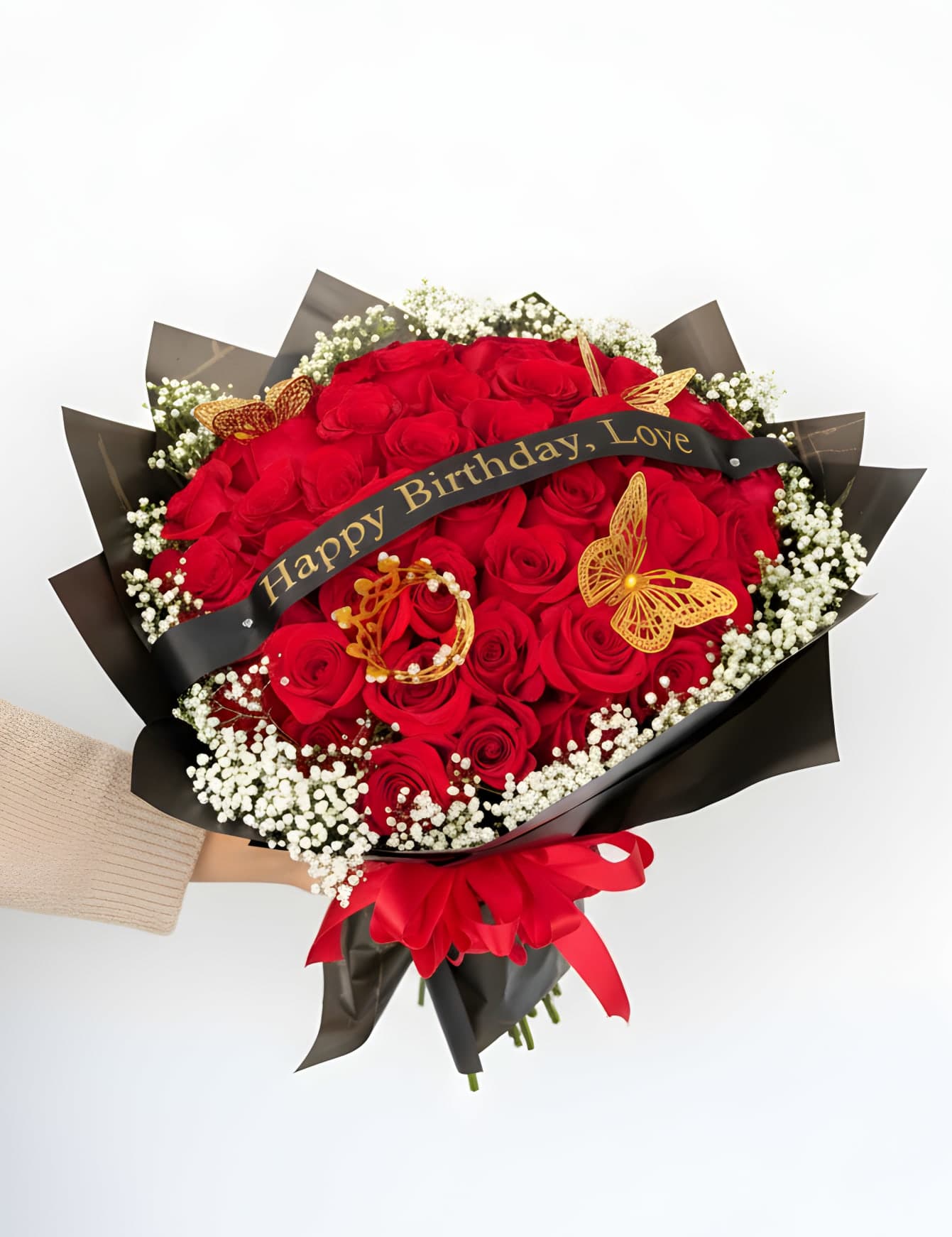 Golden Love Luxe - A luxurious expression of love and celebration, this stunning bouquet features an abundant collection of 50 rich red roses, beautifully wrapped in sleek black paper and finished with elegant gold accents. Delicate baby’s breath adds softness and texture, while decorative butterflies and a crown detail create a truly regal presentation.  Perfect for birthdays, anniversaries, or any unforgettable moment, this arrangement is designed to make a bold and lasting impression. The striking contrast of red, black, and gold gives it a modern, upscale feel that speaks of passion, elegance, and thoughtfulness.  Finished with a custom message ribbon, this bouquet is more than flowers—it’s a statement of love, celebration, and luxury. Please note that the message can be customized. Please indicate in the Florist Instructions box