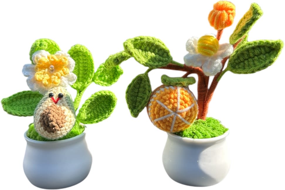 Two crocheted potted plants with flowers and fruit shapes