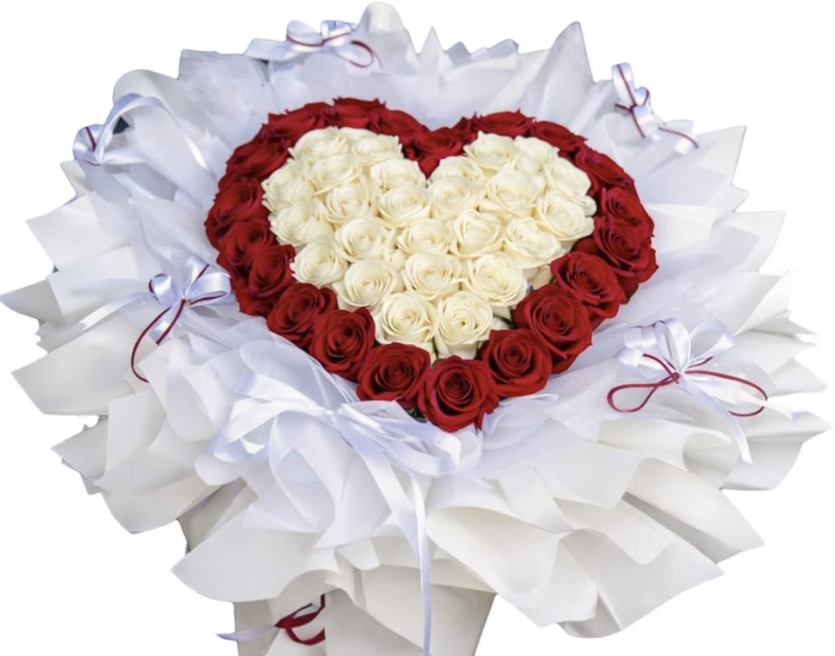 Heart-shaped bouquet of red and white roses wrapped in white paper