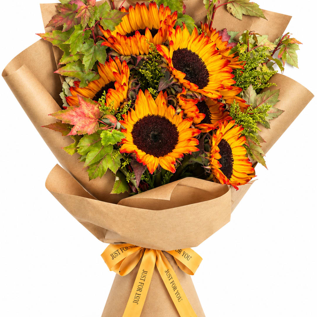 Bouquet of sunflowers wrapped in brown paper with a yellow ribbon