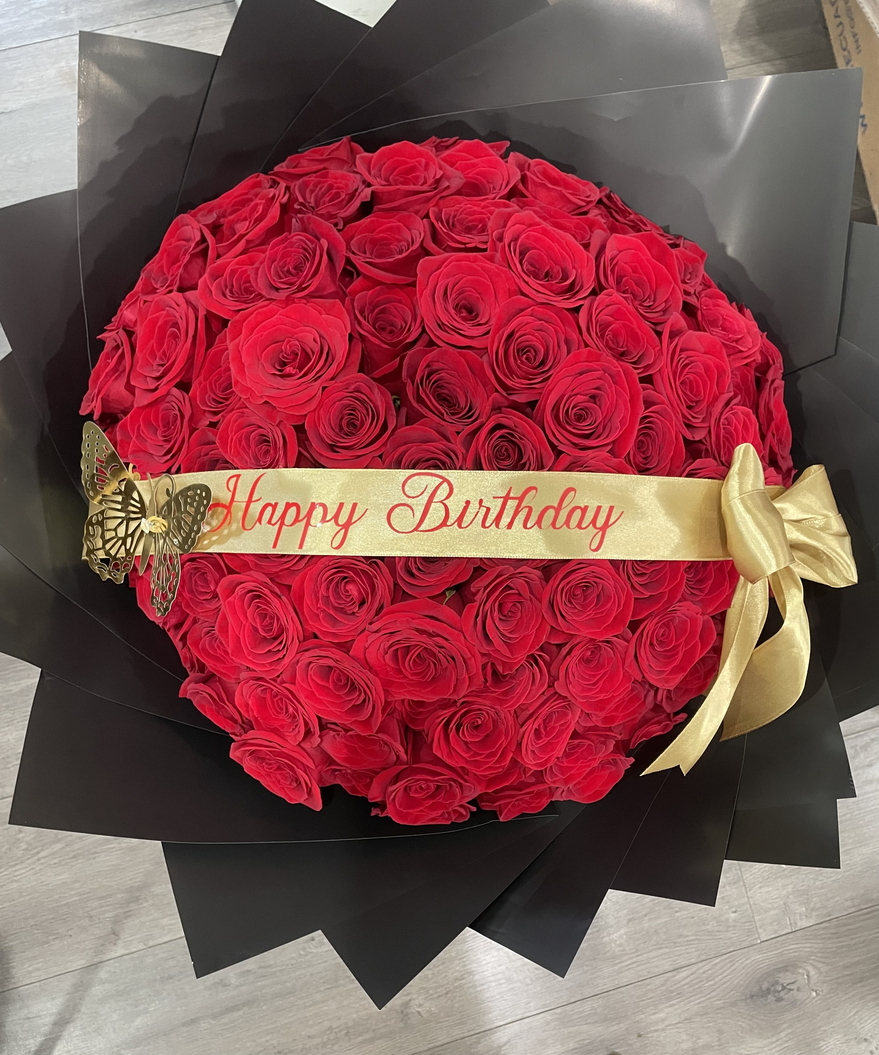 Century of Love – Birthday Buchon Edition - Make a bold birthday statement with the Century of Love – Birthday Edition, a luxurious buchón-style bouquet featuring 100 premium roses arranged in a perfectly round, eye-catching design. Known for its opulence and grandeur, the buchón style showcases lavish blooms tightly packed for maximum volume and visual impact. Finished with a festive “Happy Birthday” ribbon and a coordinating satin bow, this bouquet is a show-stopping gift that exudes celebration, love, and luxury. Ideal for making any birthday unforgettable.