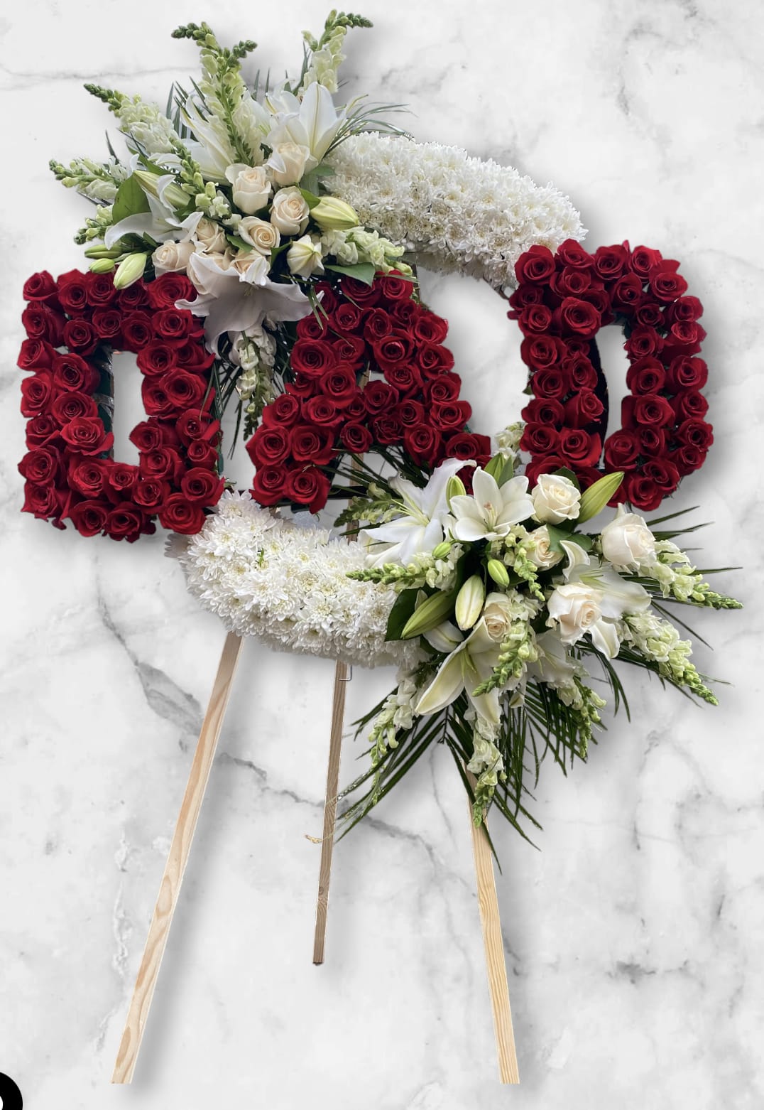 DAD Sympathy Wreath  - Beautifully custom DAD wreath to honor the memory of your beloved one. Created the base with, white chrysanthemums adding red rose in letters. With side bouquets of white rose, lily, and white snapdragon.