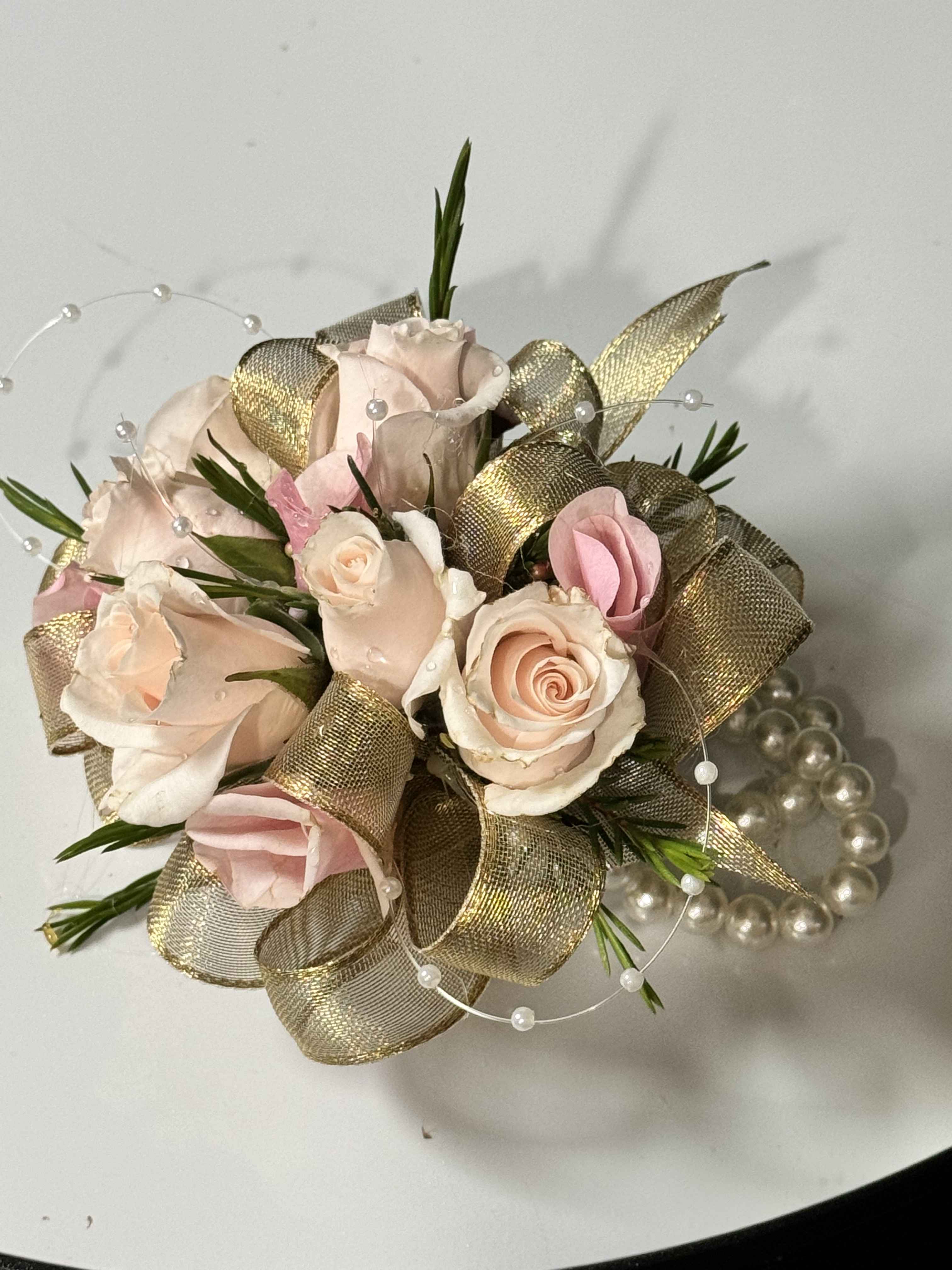 Small bouquet of pale pink roses with gold ribbon and pearl accents