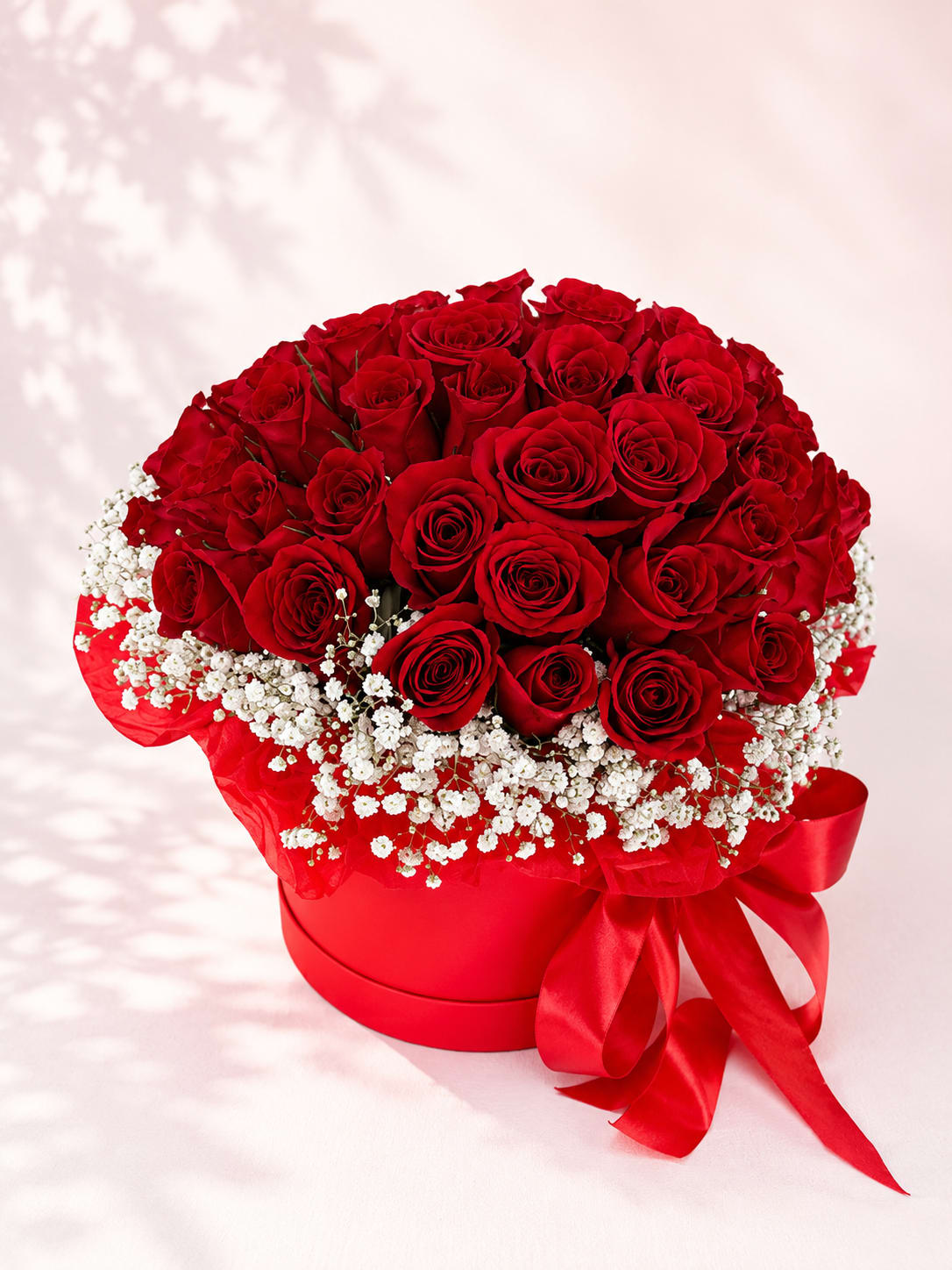 Lucina's Crimson Grace – Luxury Rose Hat Box - Inspired by Lucina, the Roman goddess of joyful beginnings and life's most cherished moments, Lucina's Crimson Grace is a timeless expression of elegance and romance. Premium long-stem red roses are artfully arranged in Flower Fairy's signature keepsake hat box and delicately framed with airy baby's breath, creating a luxurious design that never goes out of style.  Handcrafted using the freshest premium roses available, this sophisticated arrangement is perfect for anniversaries, Valentine's Day, proposals, birthdays, romantic surprises, or simply reminding someone how deeply they are loved.  Each arrangement is individually handcrafted, making every design naturally unique while preserving its signature luxurious appearance.  Features: Premium long-stem red roses Delicate baby's breath accents Luxury keepsake hat box Handcrafted by Flower Fairy Same-day flower delivery throughout the Phoenix Metro Area Designed by your local Phoenix florist