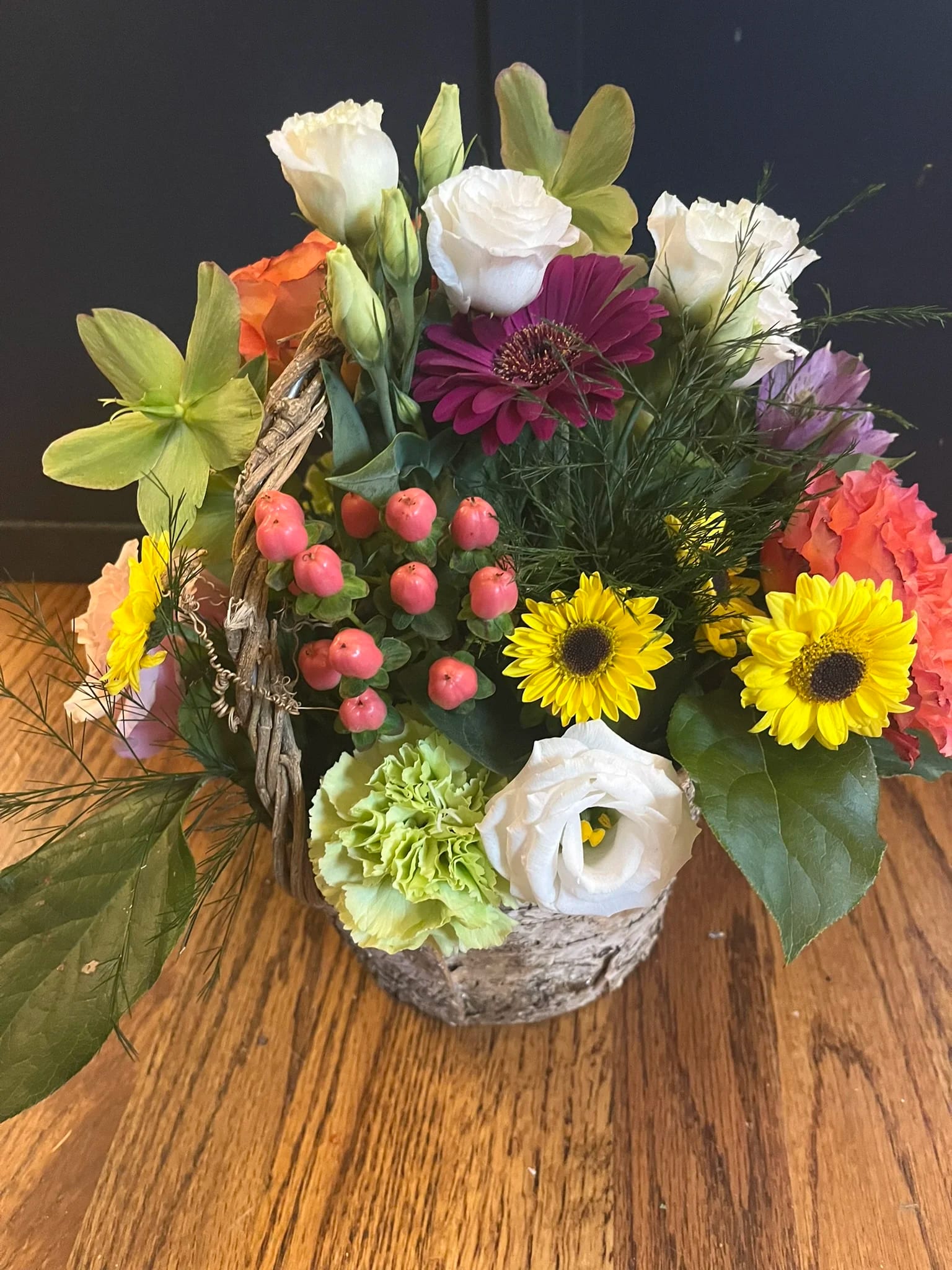 Colorful mixed flower arrangement in a birch basket with bright blooms