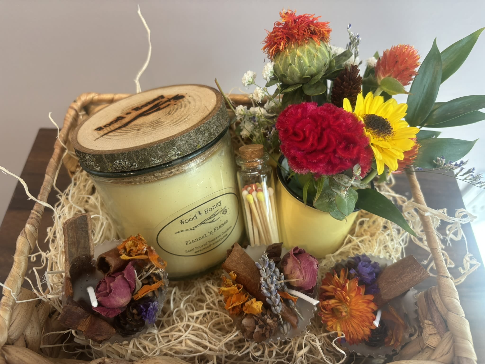 Gift basket with a candle, matches, and a small flower arrangement