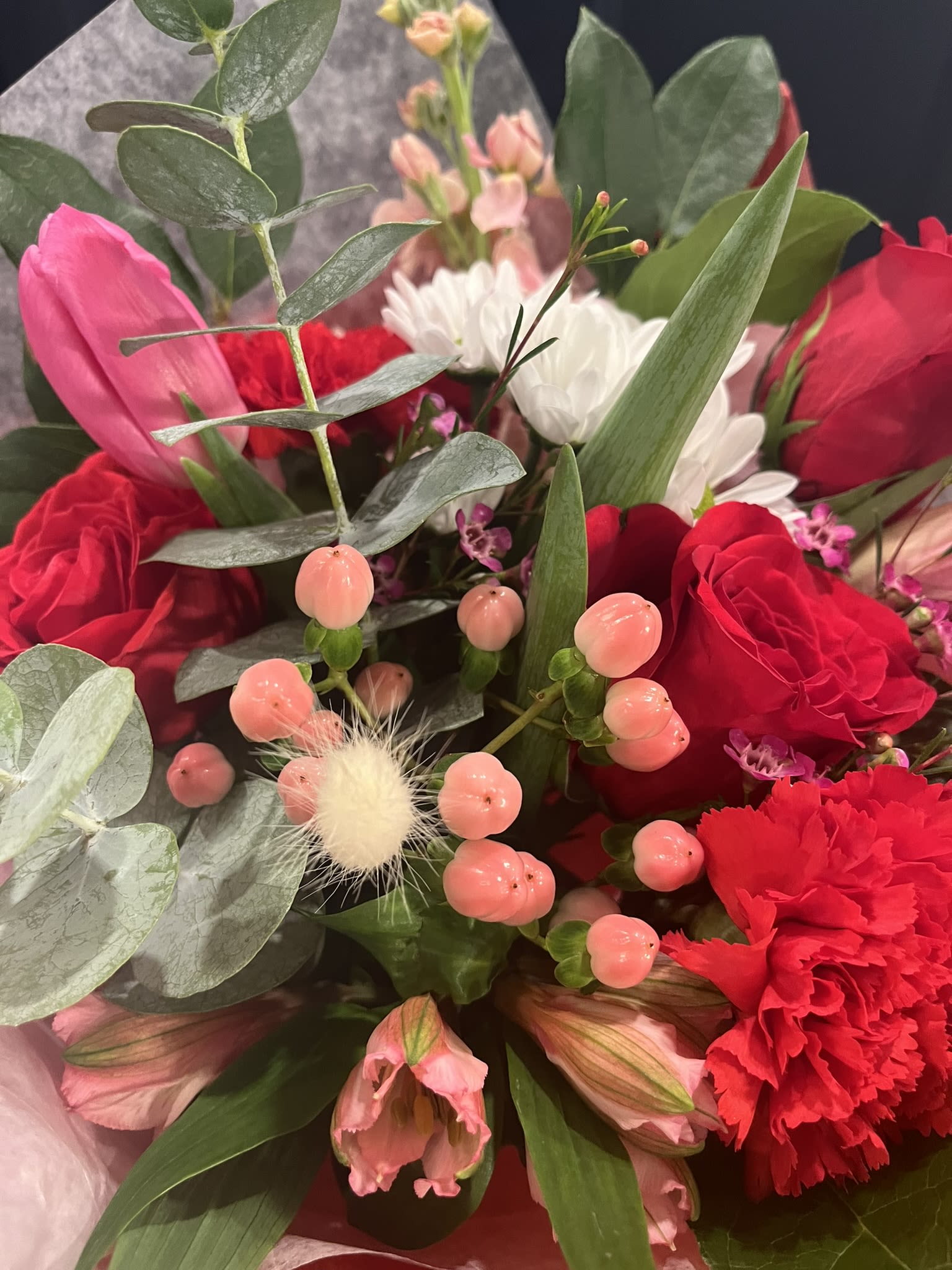 Bouquet of red and pink flowers with white daisies and eucalyptus