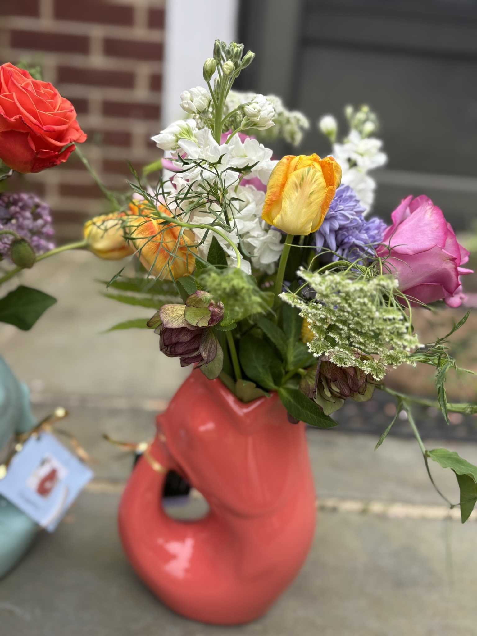 Gurgle Pot Bouquet - A colorful Gurgle Pot bursting with whimsical fresh local blooms.  The flowers change depending on the season.  A Gurgle Pots is a food safe stoneware created to be used a pitcher and make a signature "gurgling" sound.  The Pots are provided through a collaboration with The Boxwood Collection, a local boutique for heart and home, that partners with Sow Wonder to provide gifts with a floral twist.  When choosing pick-up, you'll be picking up at 15 Railroad Ave, Glyndon MD unless noted otherwise.  Deliveries are also available.    For Mother's Day, you can request a color by adding it to the notes.  If we can meet that color, we will since Gurgle Pots come in all sorts of colors.  The pots also come in a matt white.    