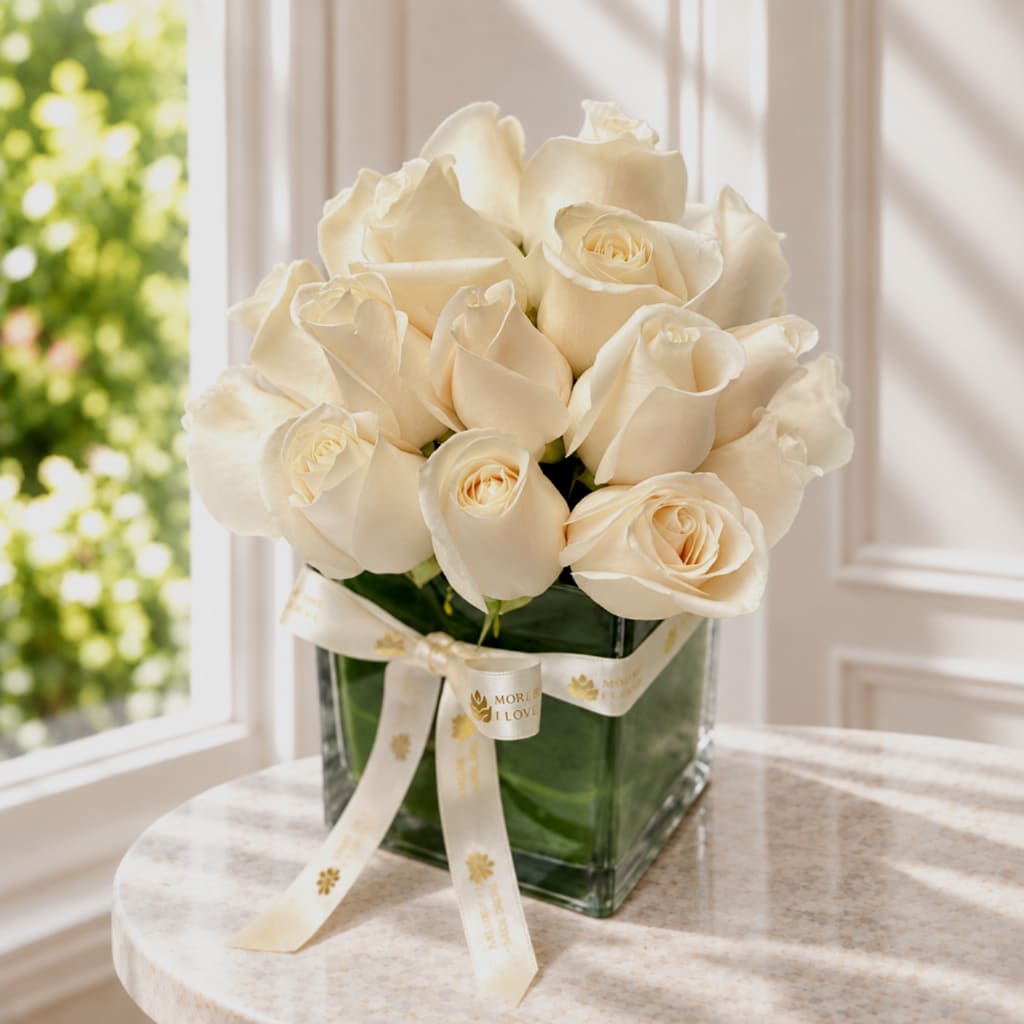 Bouquet of cream roses in a square glass vase with a ribbon