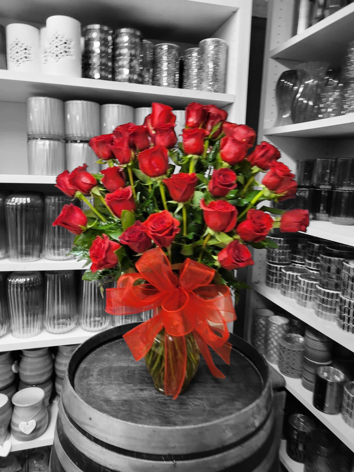 Bouquet of red roses in a glass vase with a red ribbon
